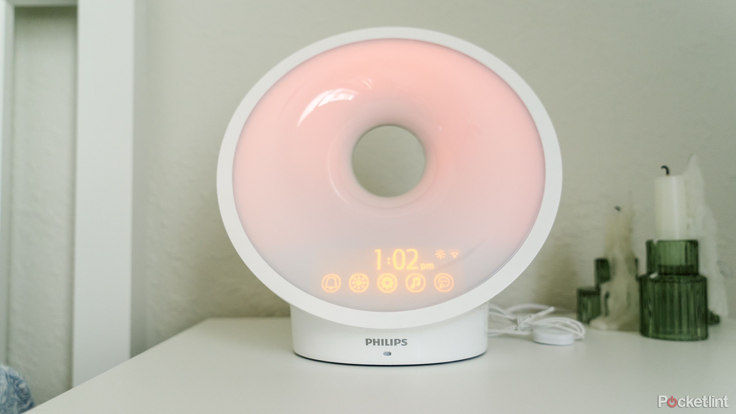 The Philips SmartSleep Connected Sleep and Wake Light HF3670/60 glowing red on a white nightstand.