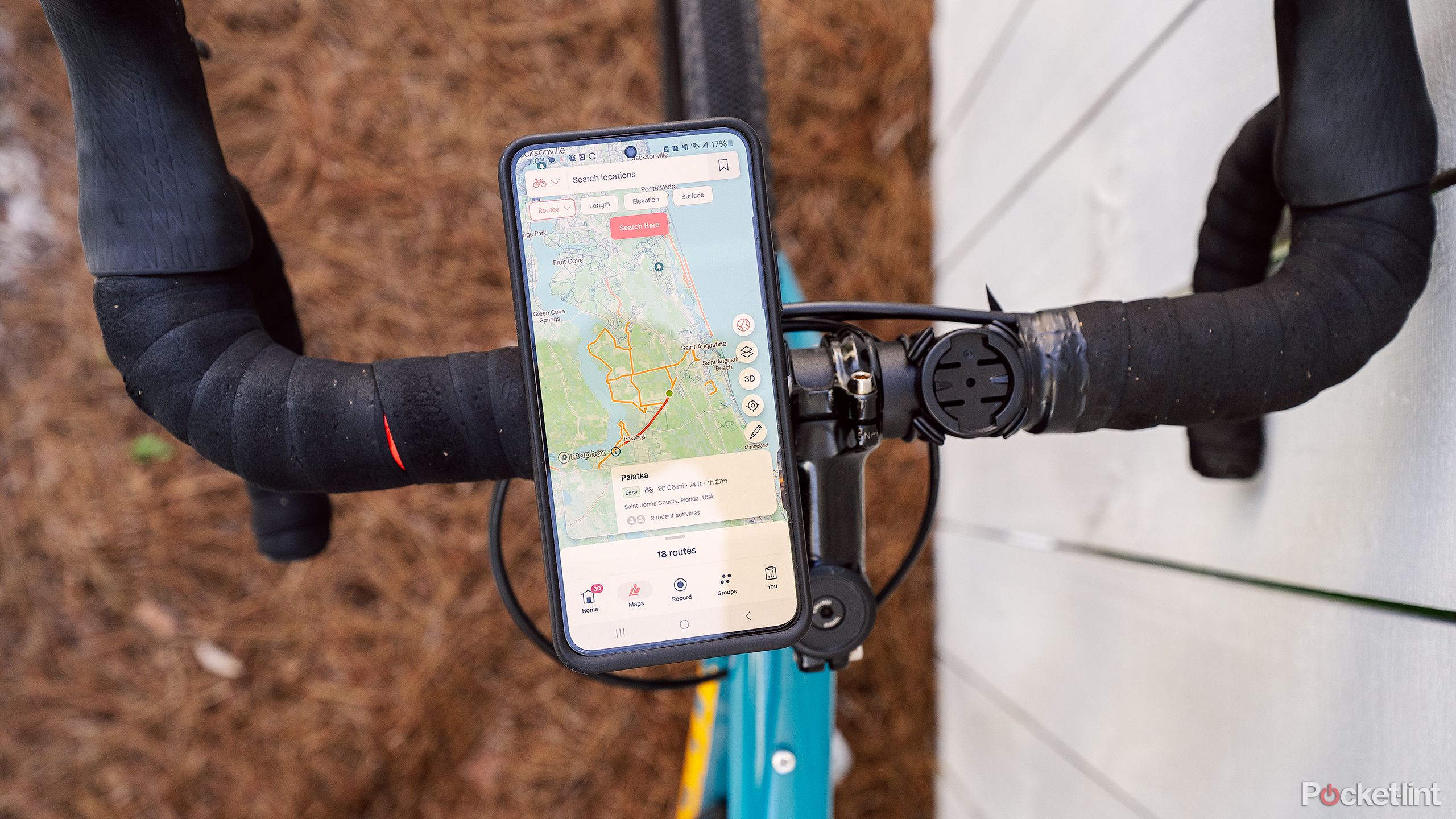 A phone with Strava on the display attached to bike handlebars. 