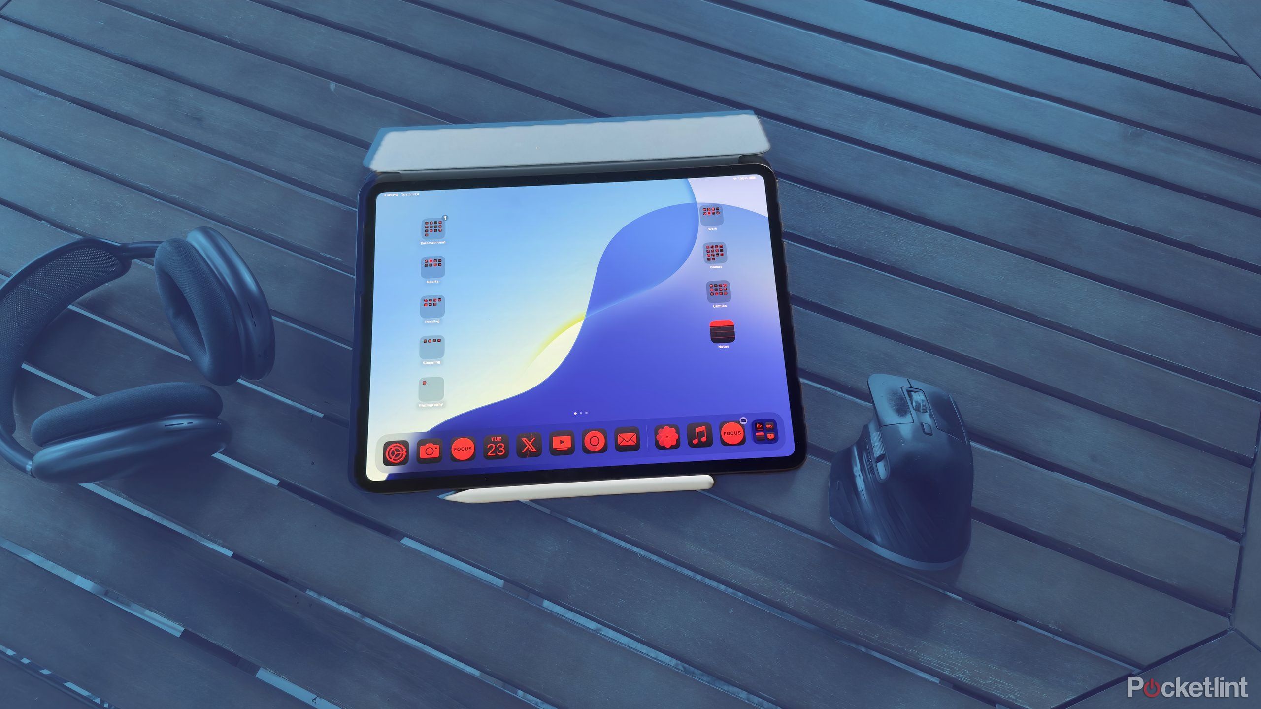 an iPad, AirPods Max headphones and a mouse sitting on a table together