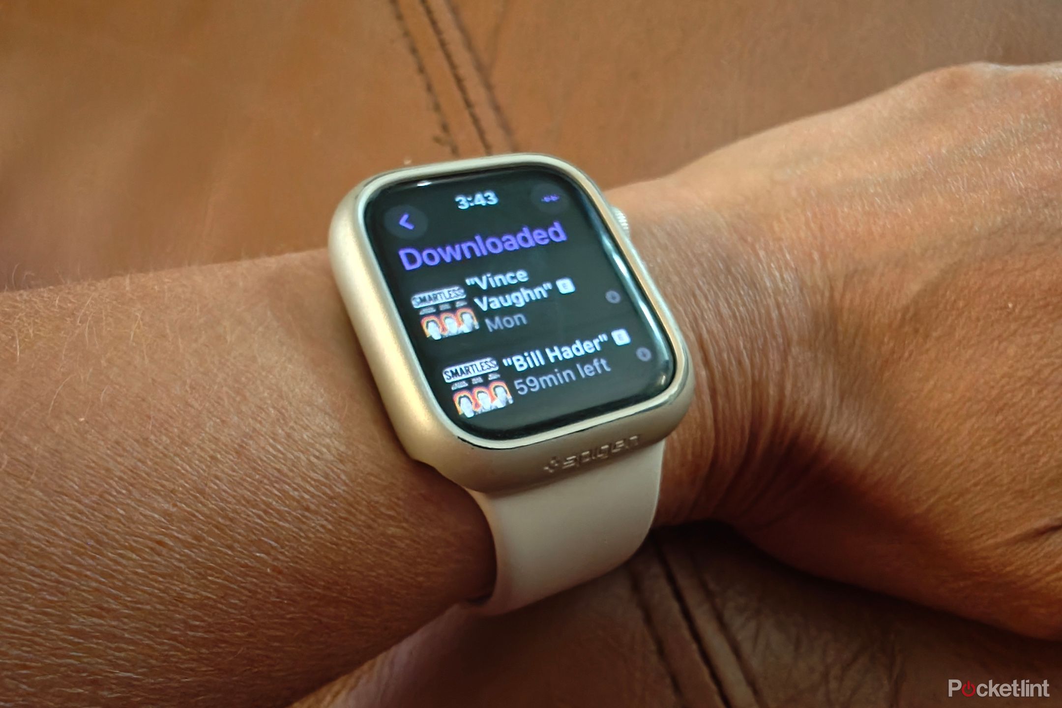 An Apple Watch on wrist showing downloaded Podcast episodes.