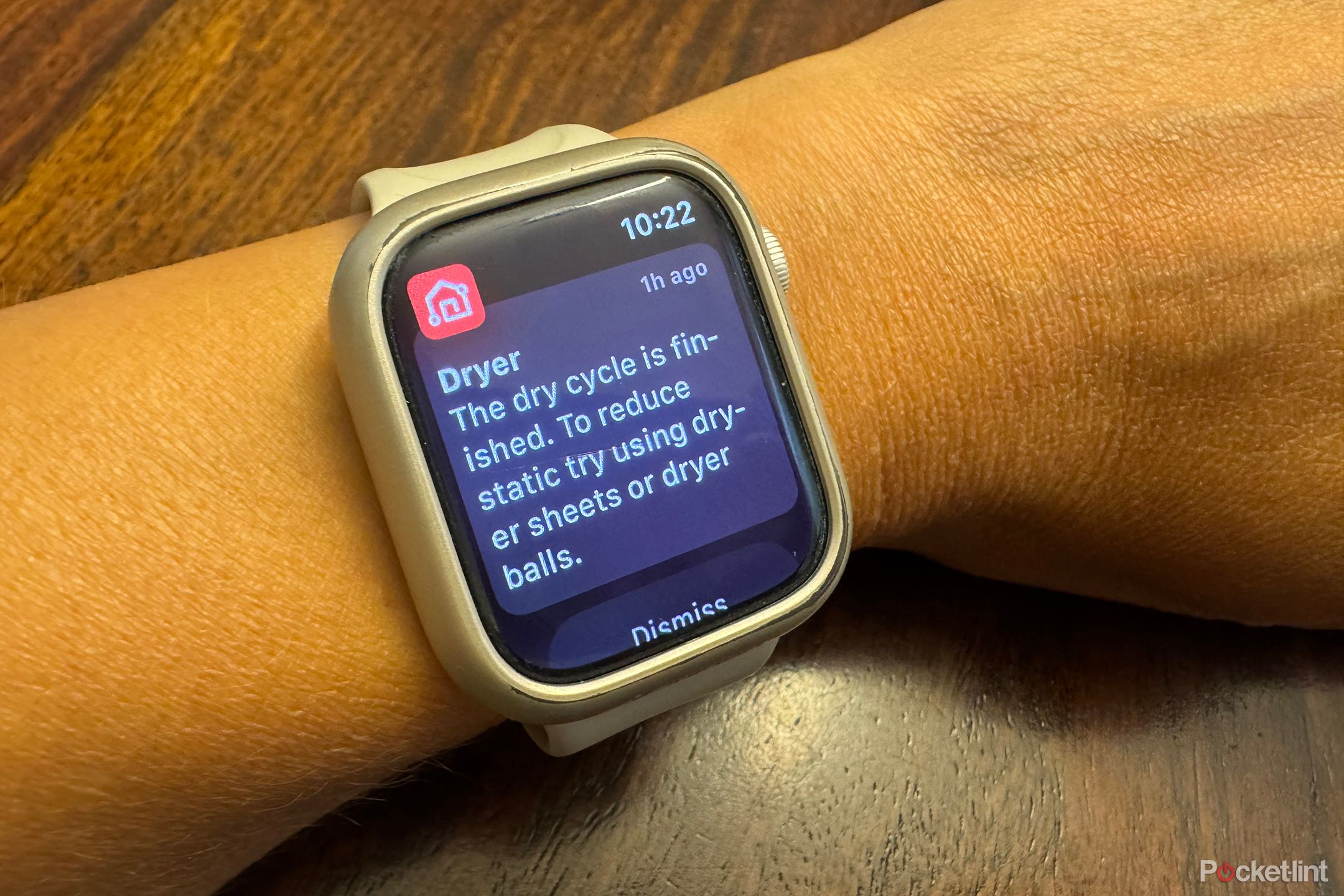 An Apple Watch on a wrist showing a notification from the LG ThinQ app about a dryer cycle being finished.