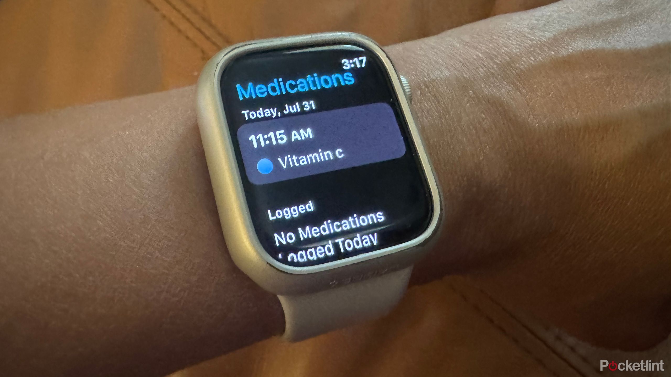 An Apple Watch on wrist showing a medication reminder for Vitamin C.