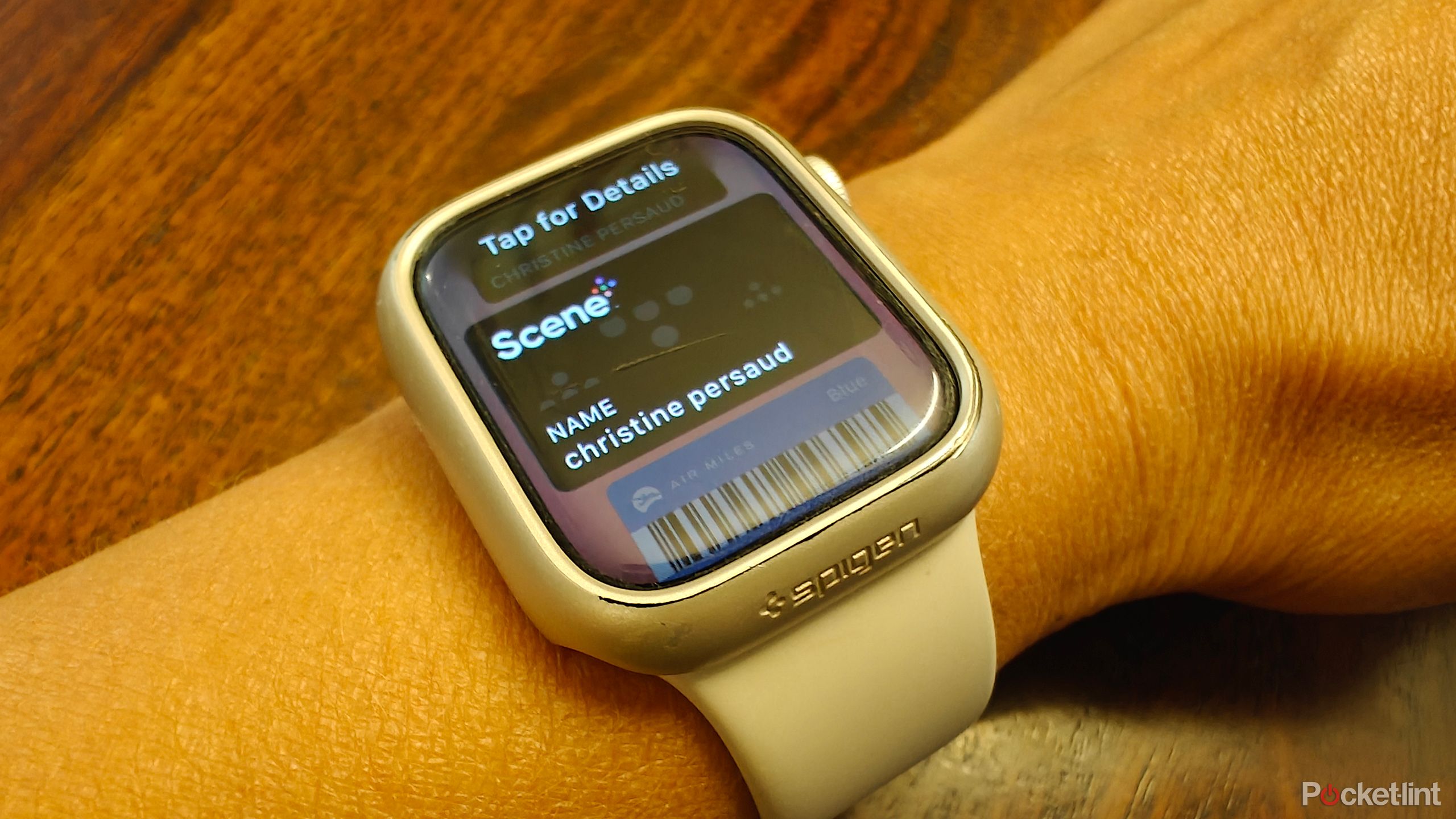 An Apple Watch on a wrist showing a Scene loyalty card.