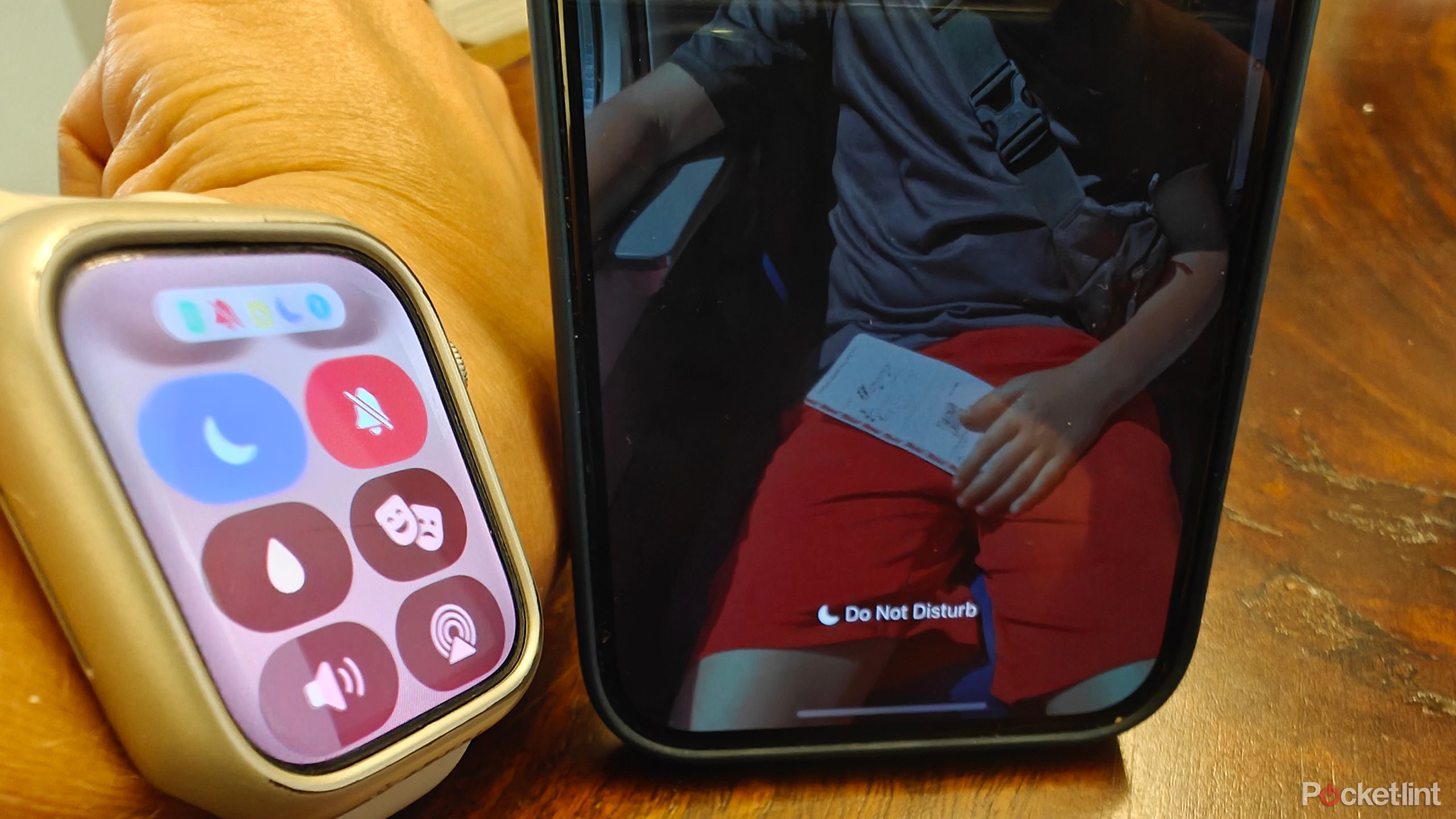 An Apple Watch beside an iPhone with both showing they are in Do Not Disturb mode.