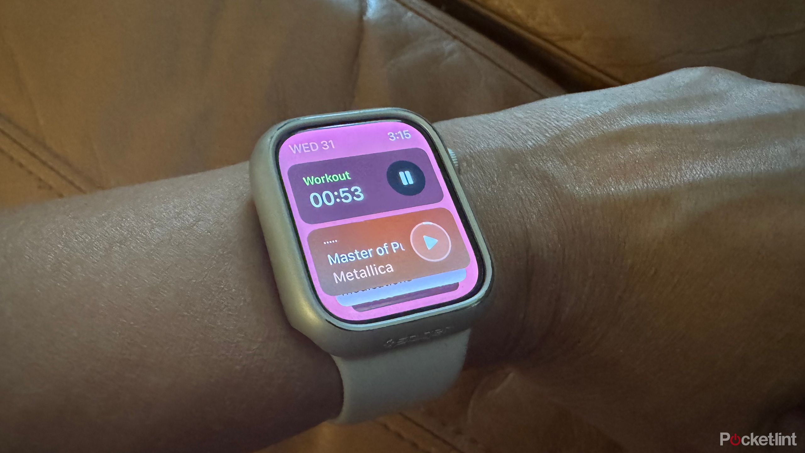 an Apple Watch on a wrist showing the Stack view with an active workout and song playing.