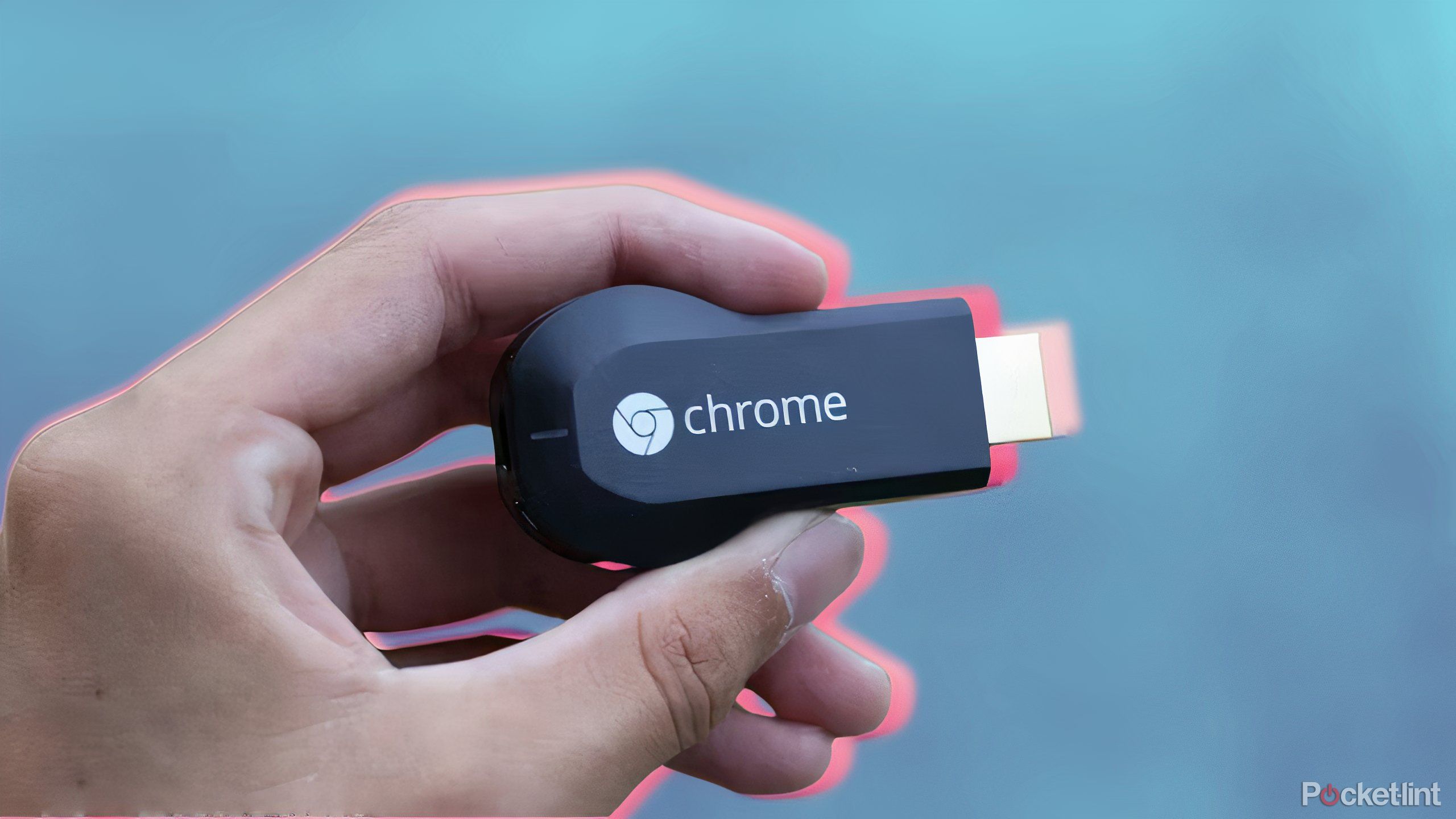 Someone holding a first generation Chromecast.