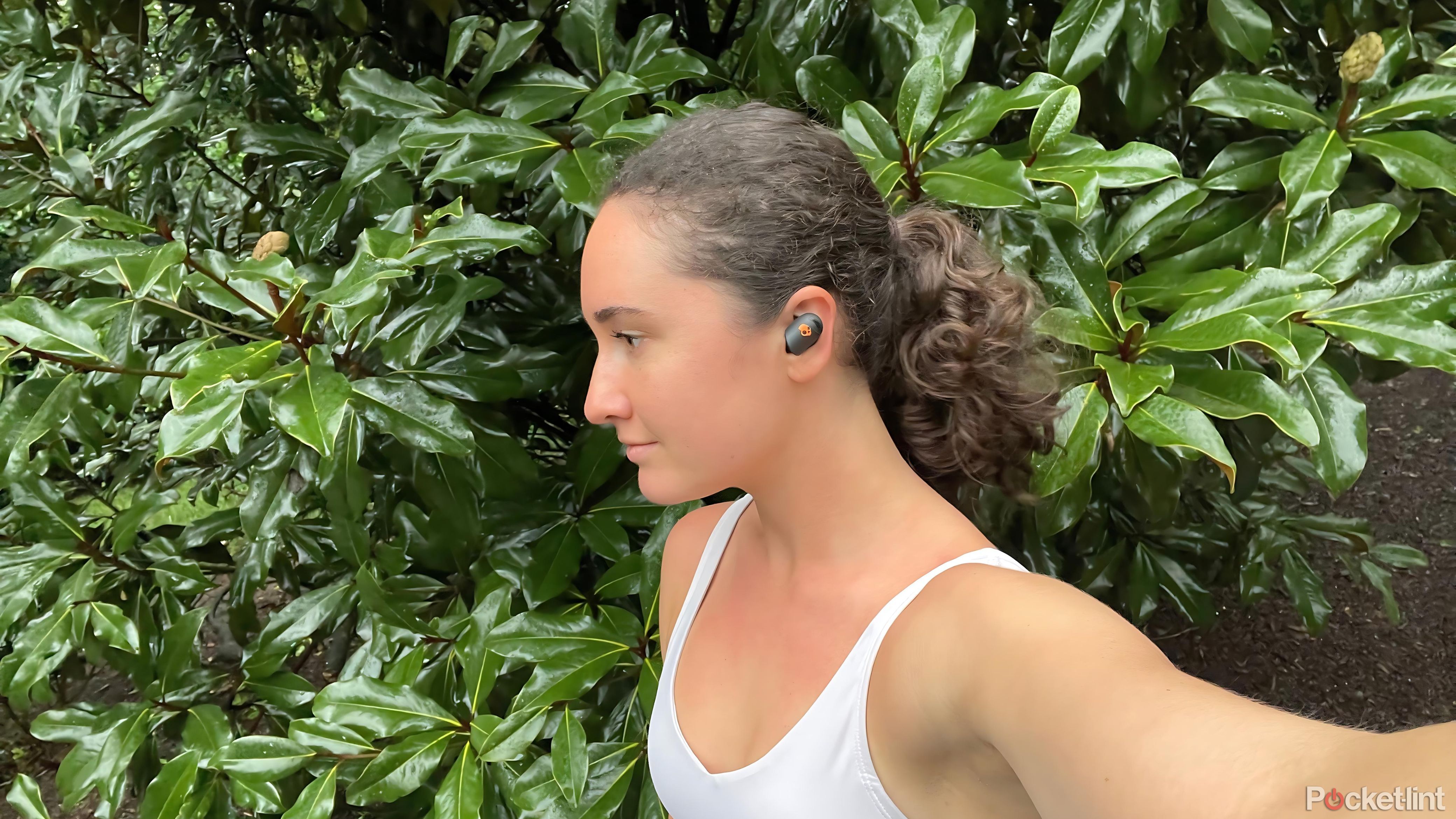 A woman's profile wearing the Skullcandy ANC Sesh Active buds. 