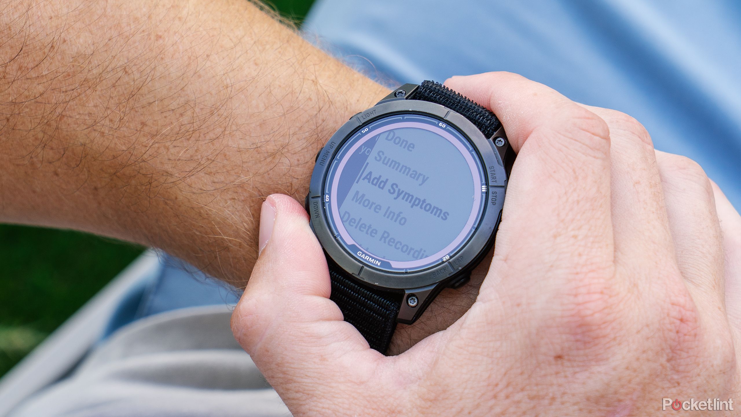 A hand presses buttons on the Garmin Fenix 7 Sapphire Solar while it is on their wrist. 