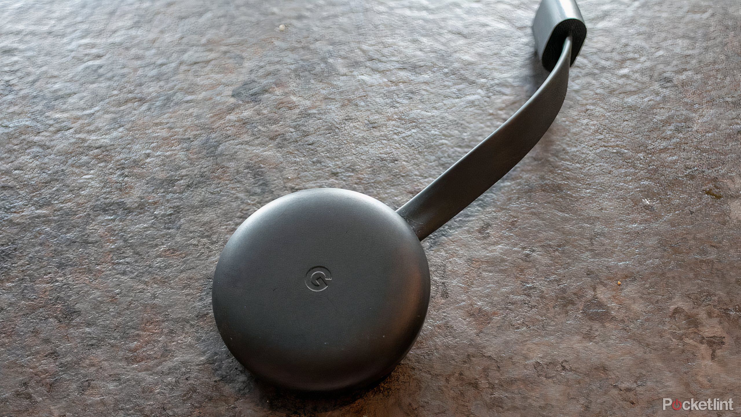 The rounder, smoother third generation Google Chromecast on a countertop.