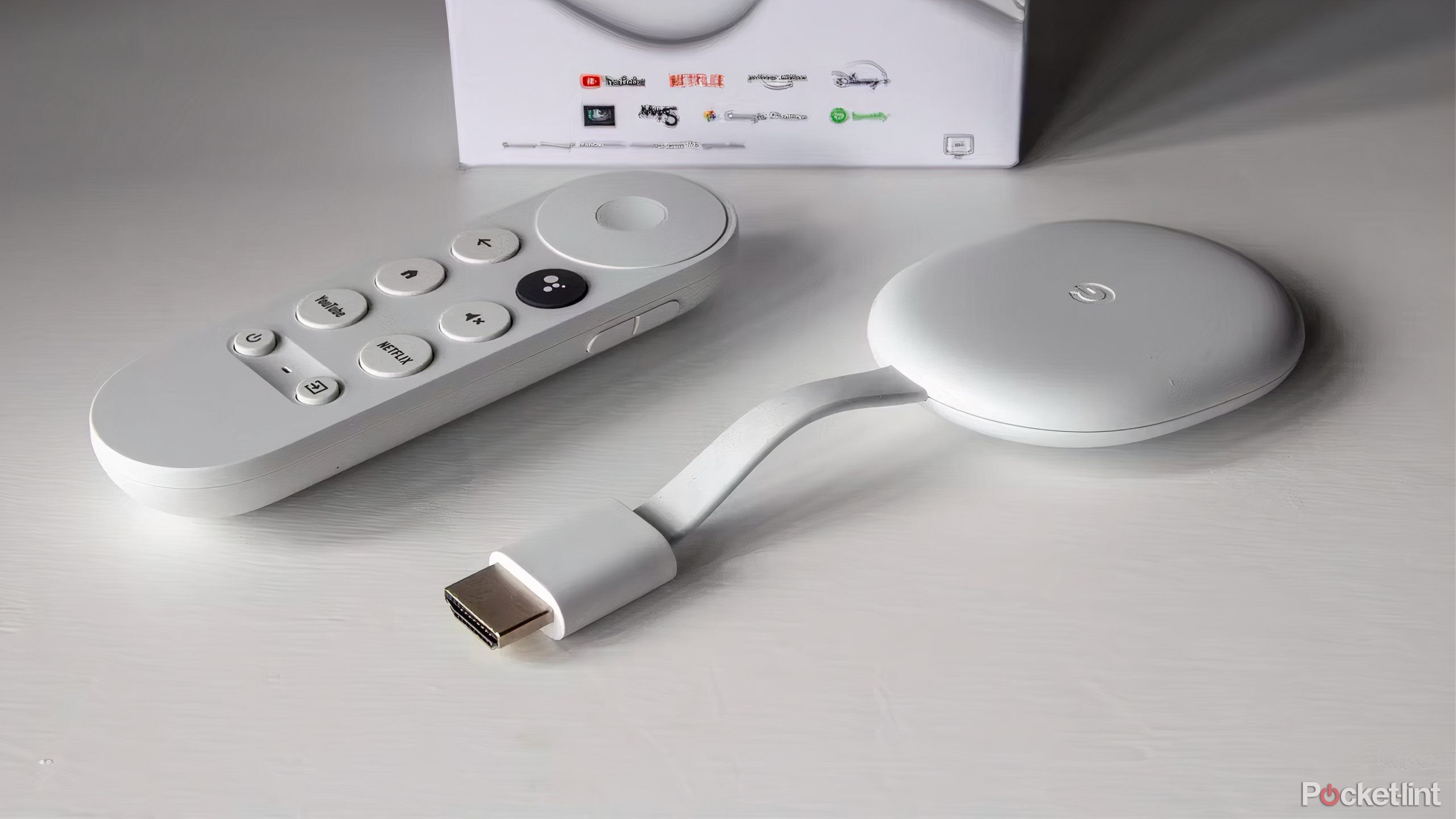 A Chromecast with Google TV and its remote laying on a white table.