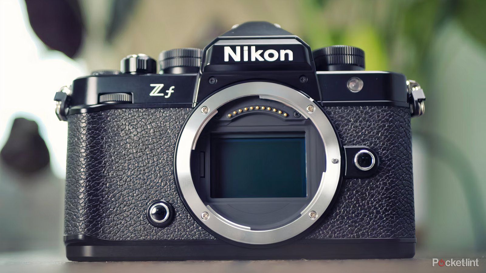 The Nikon Zf is shown without a lens sitting on a table