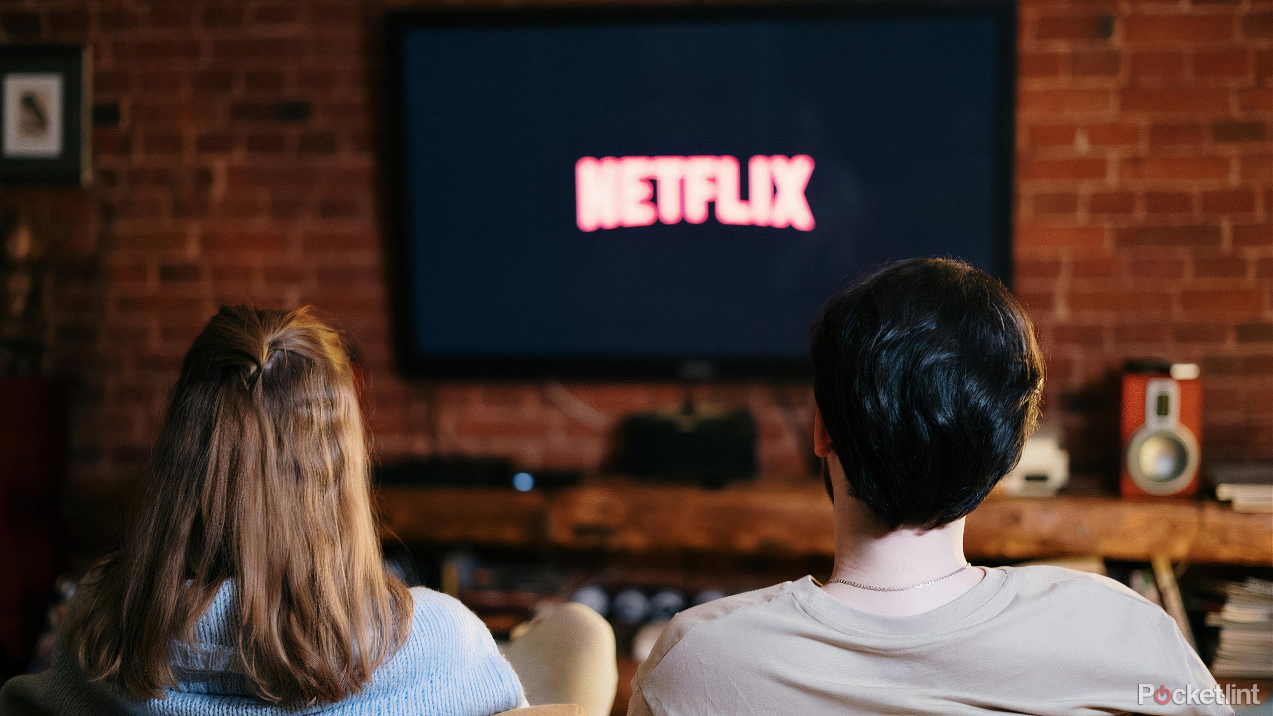 A man and a woman watching Netflix on a Tv.