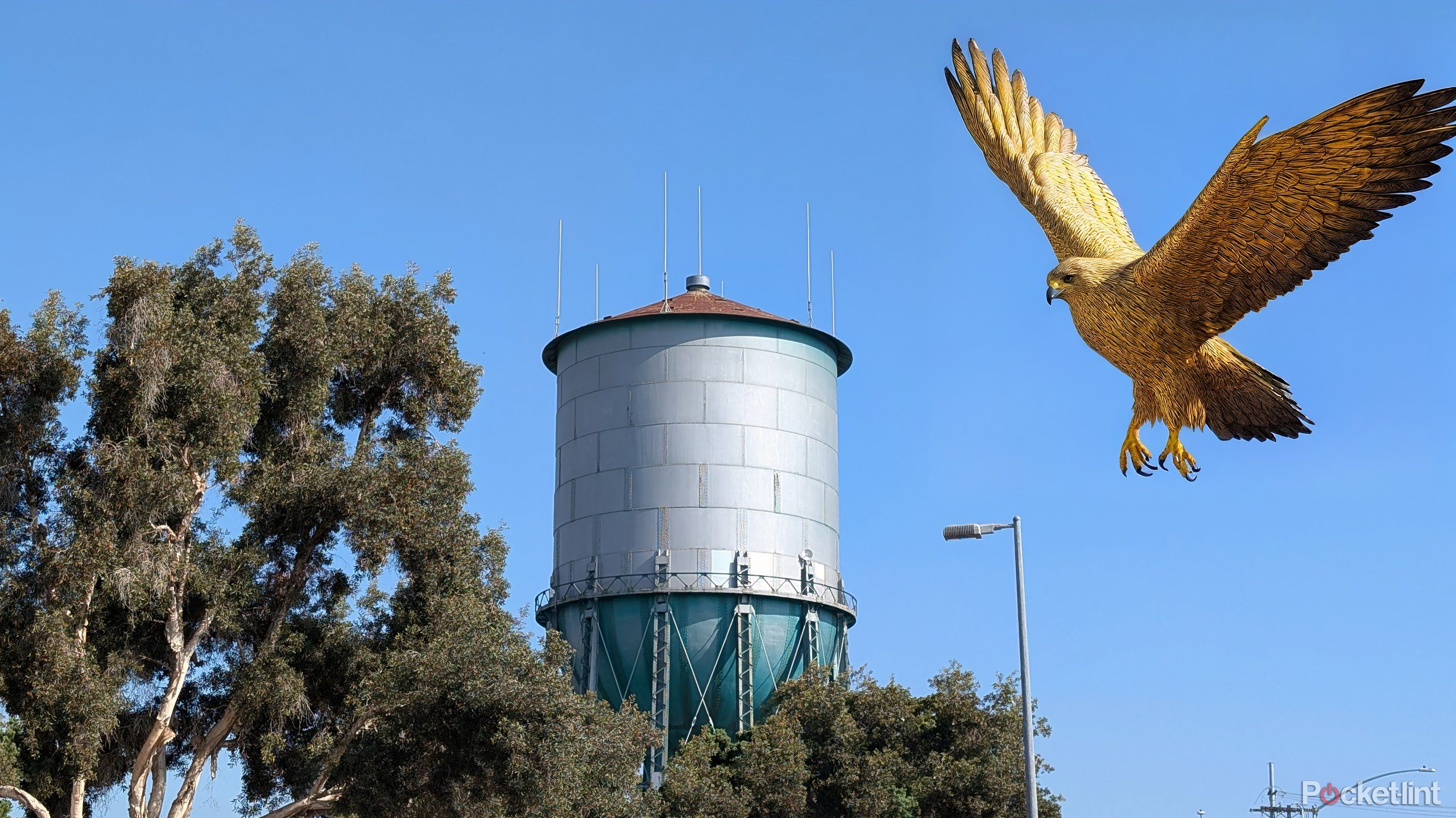 A golden falcon swoops down on a water tower.