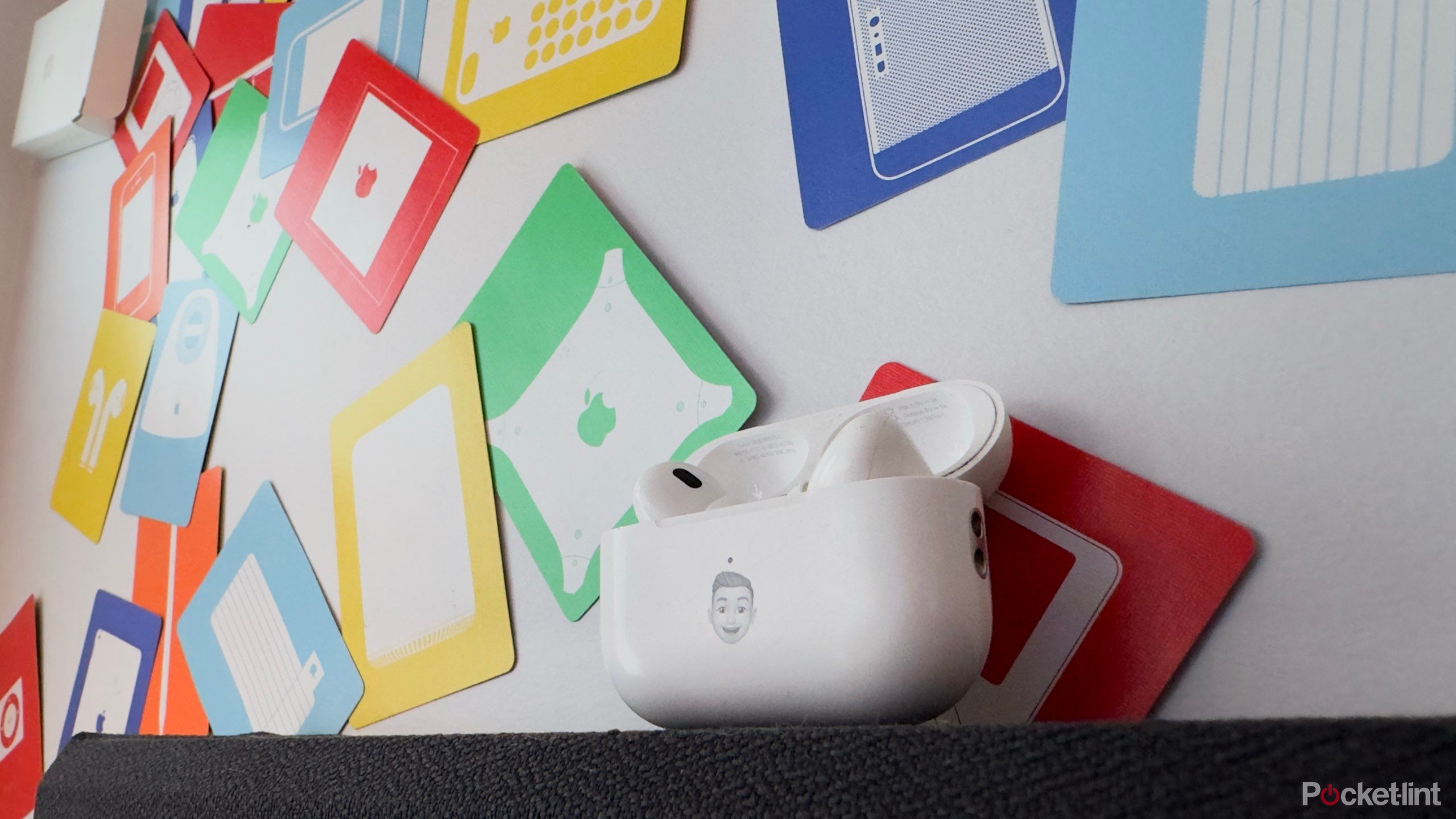 AirPods Pro 2 against a multi-coloured backdrop of Apple playing cards.