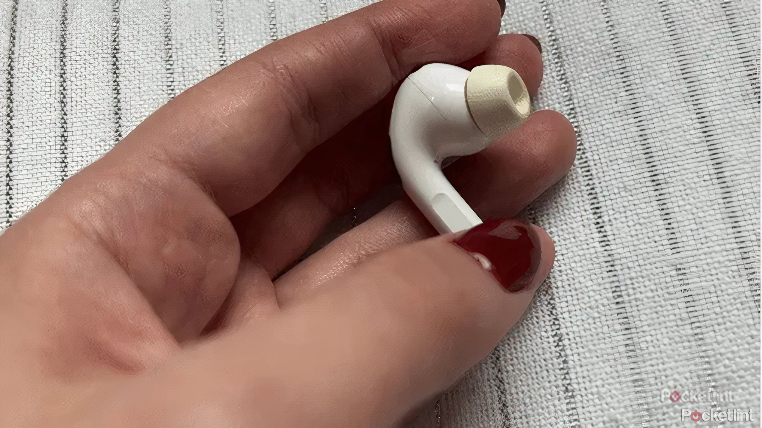 AirPod held in a person's hand