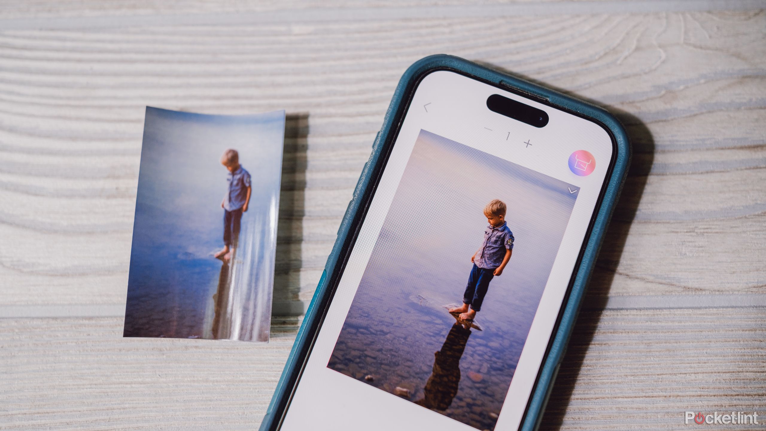 An iPhone with a printed photo from the Canon Ivy 2