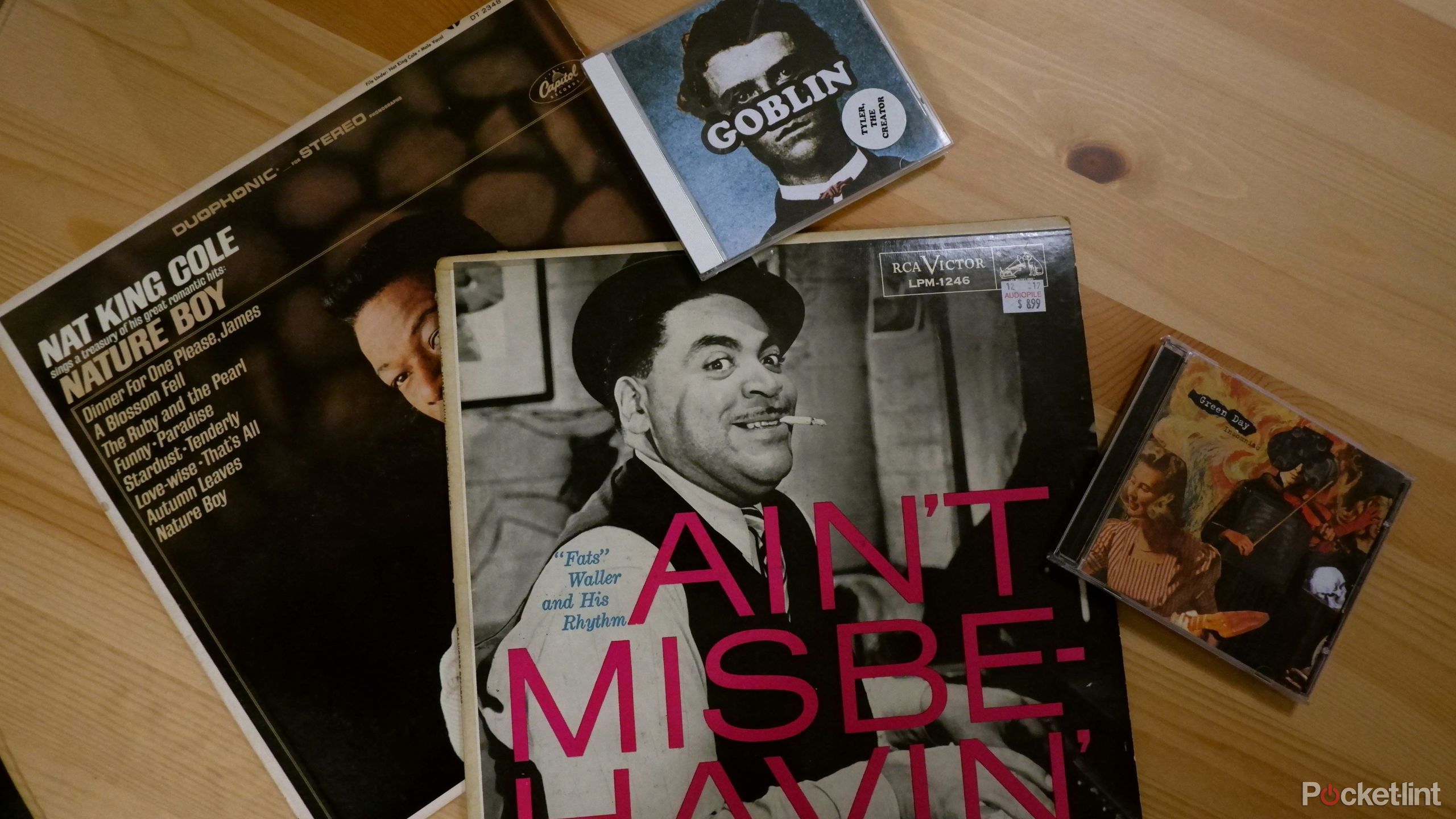 Two CDs and two vinyl records on a wooden table