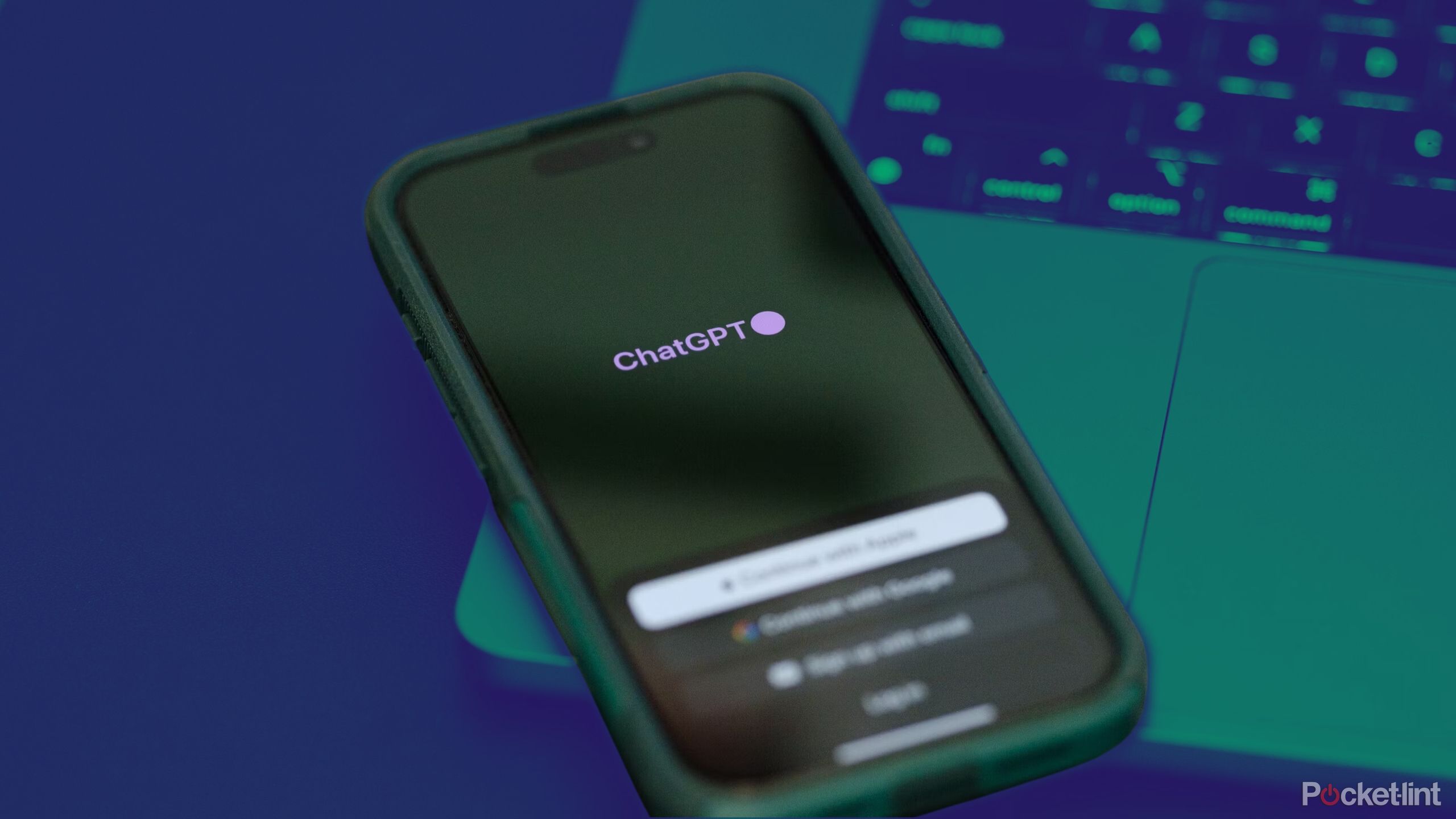 ChatGPT app running on phone on top of Macbook on colored background