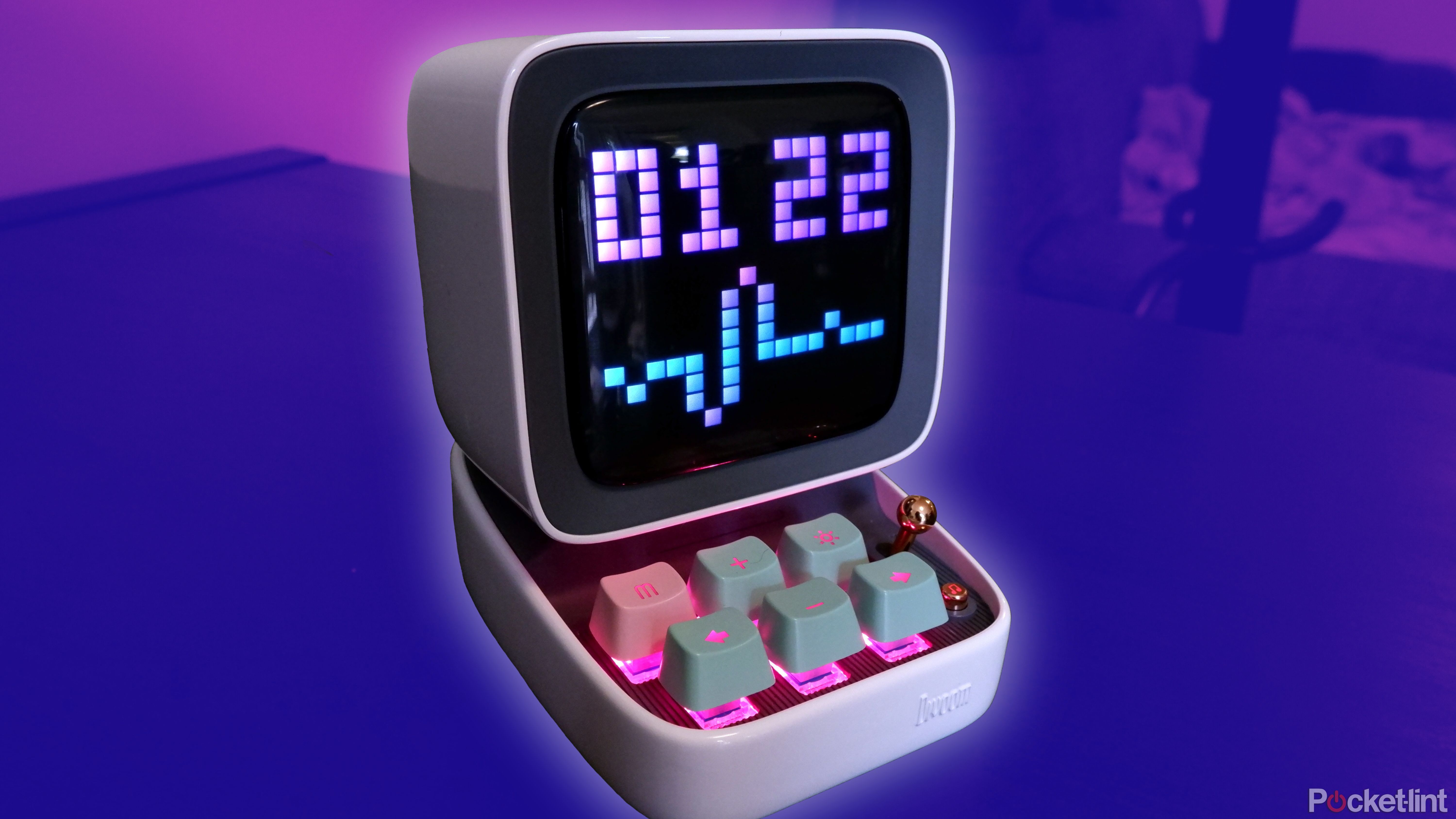 The Divoom Ditoo bluetooth speaker on a shelf, with an edited purple background