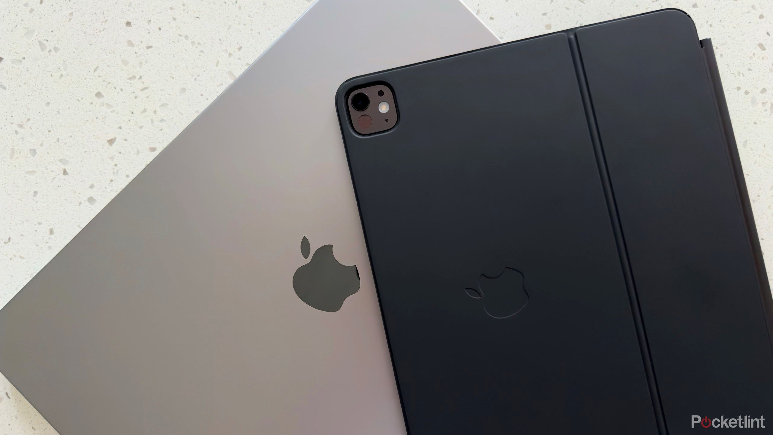 Space Grey MacBook Pro and Space Black iPad Pro with a Magic Keyboard.