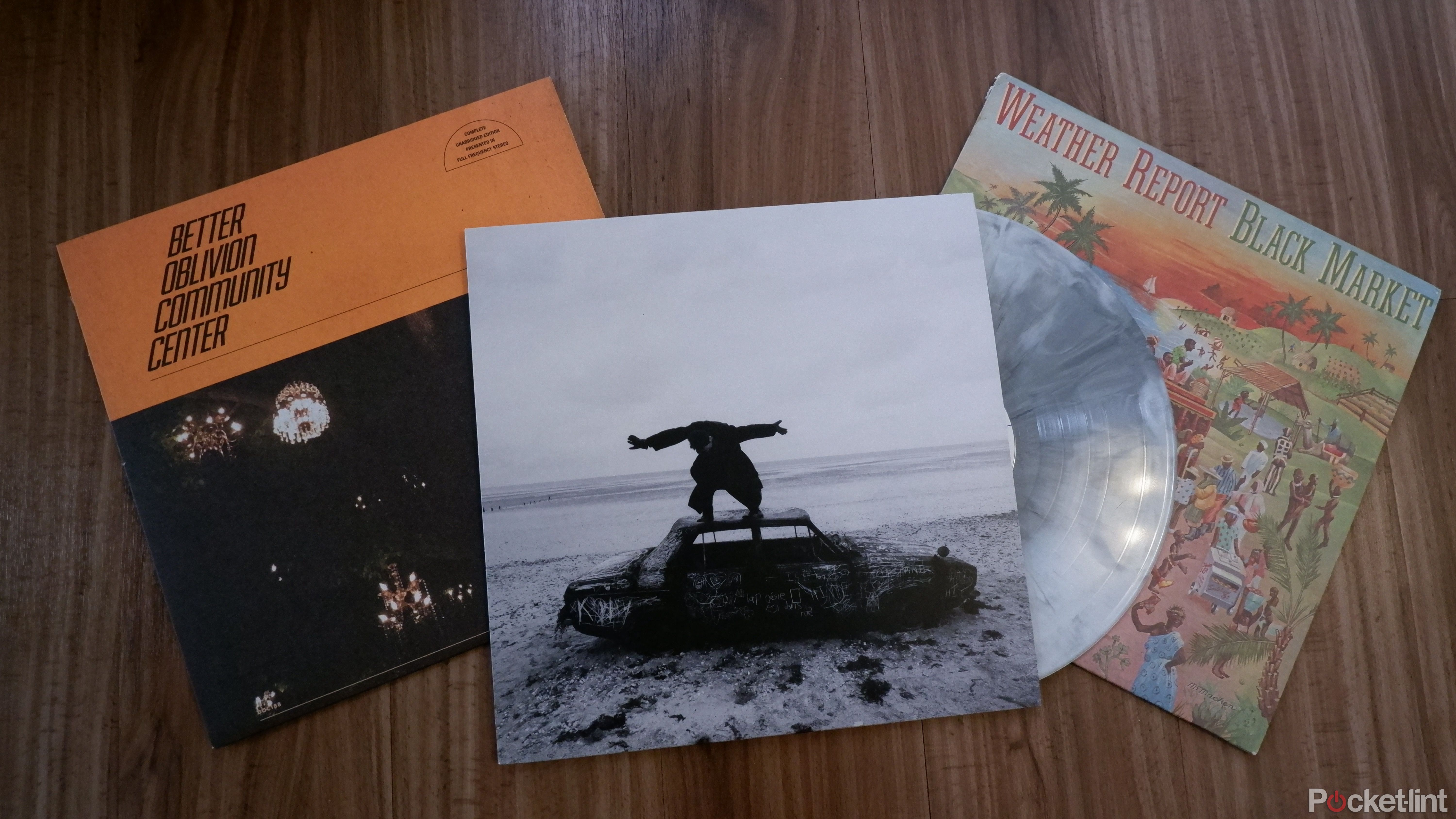 Three records in their jackets on the floor, from left to right: Better Oblivion Community Center's self-titled record, The 1975's Being Funny In A Foreign Language, with the record peeking out the right side, and Weather Report's Black Market.