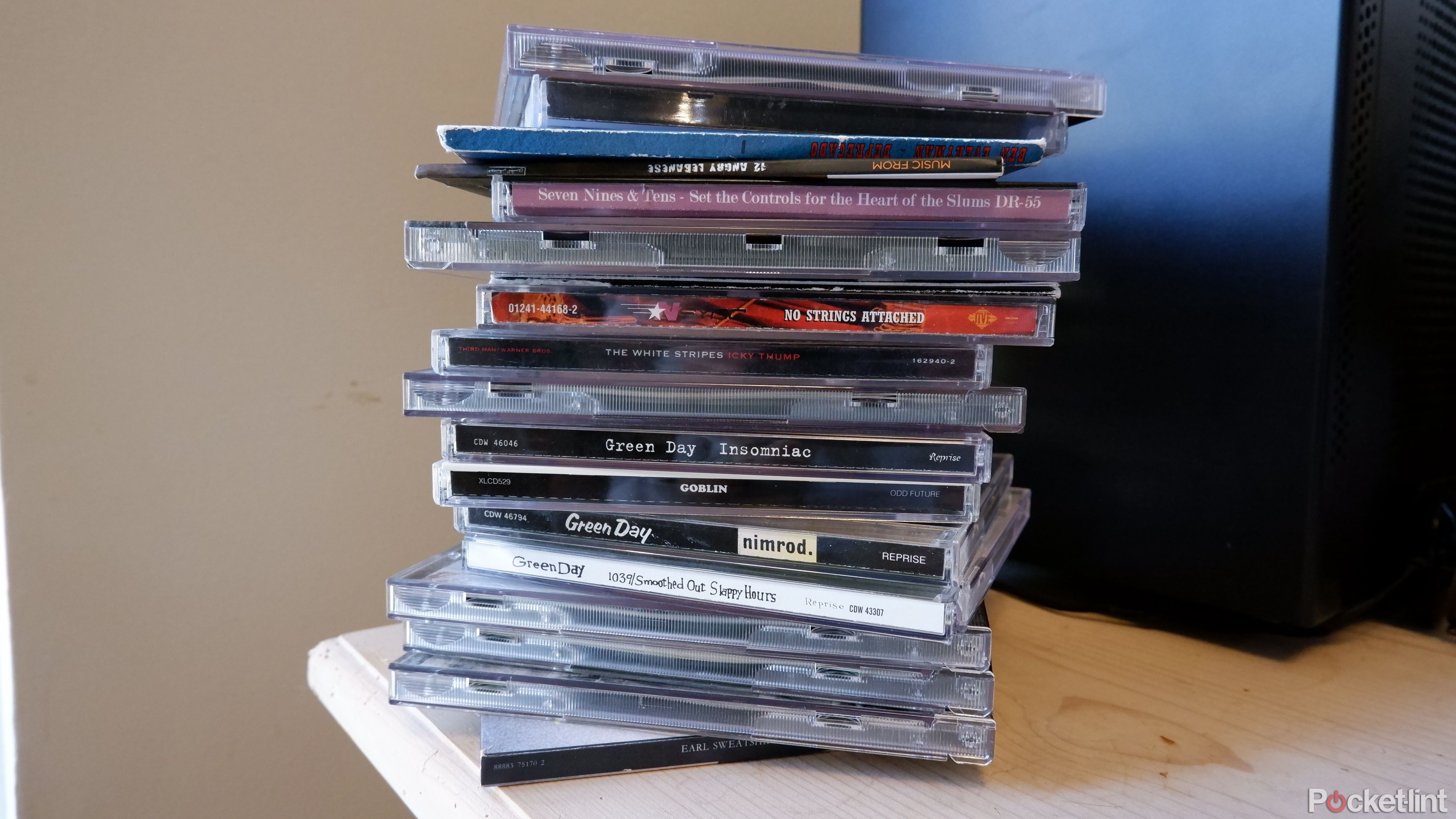 A pile of CDs on a wooden desk