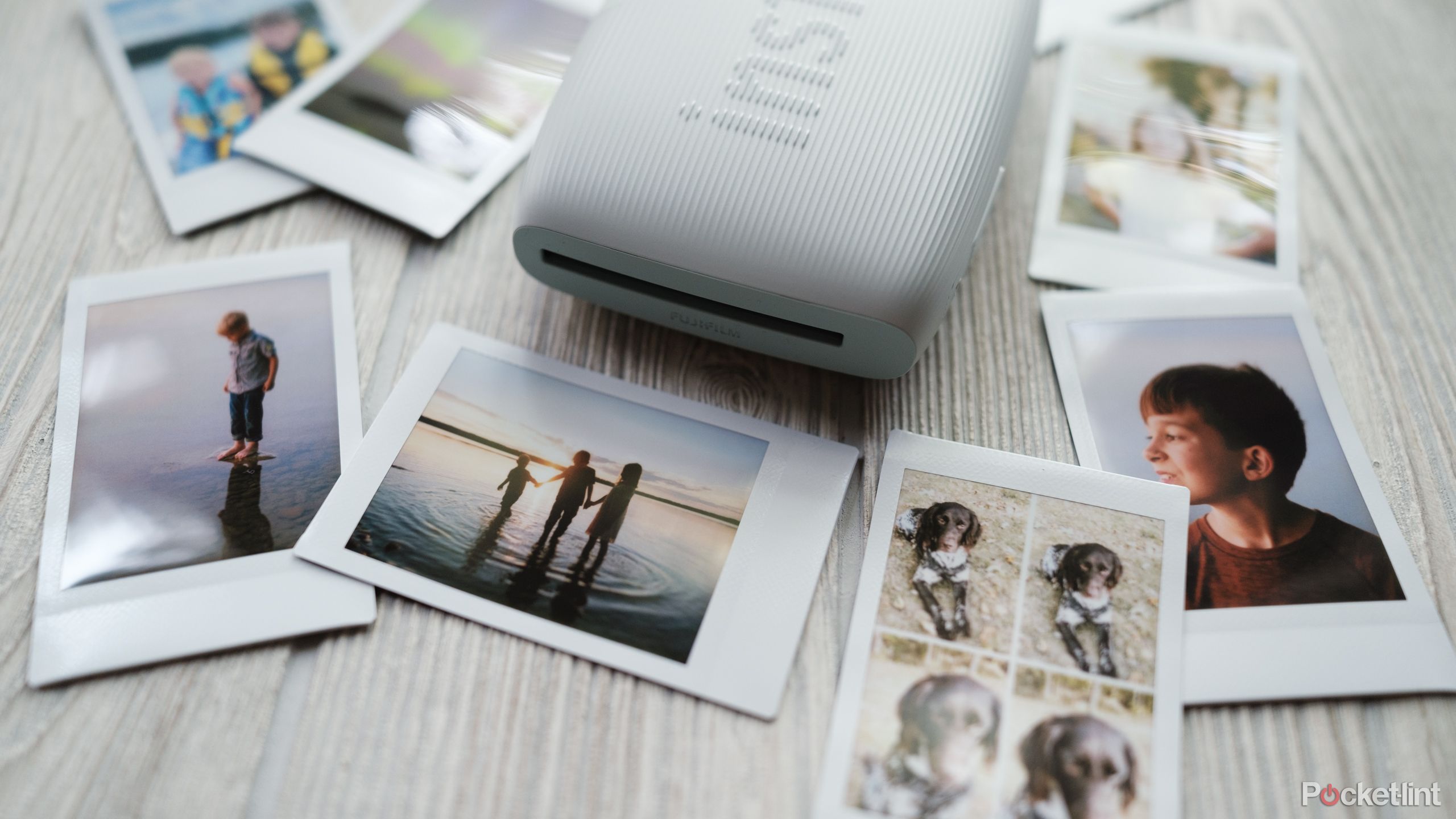 The Fujifilm Instax Mini Link 3 with instant photos on a desk