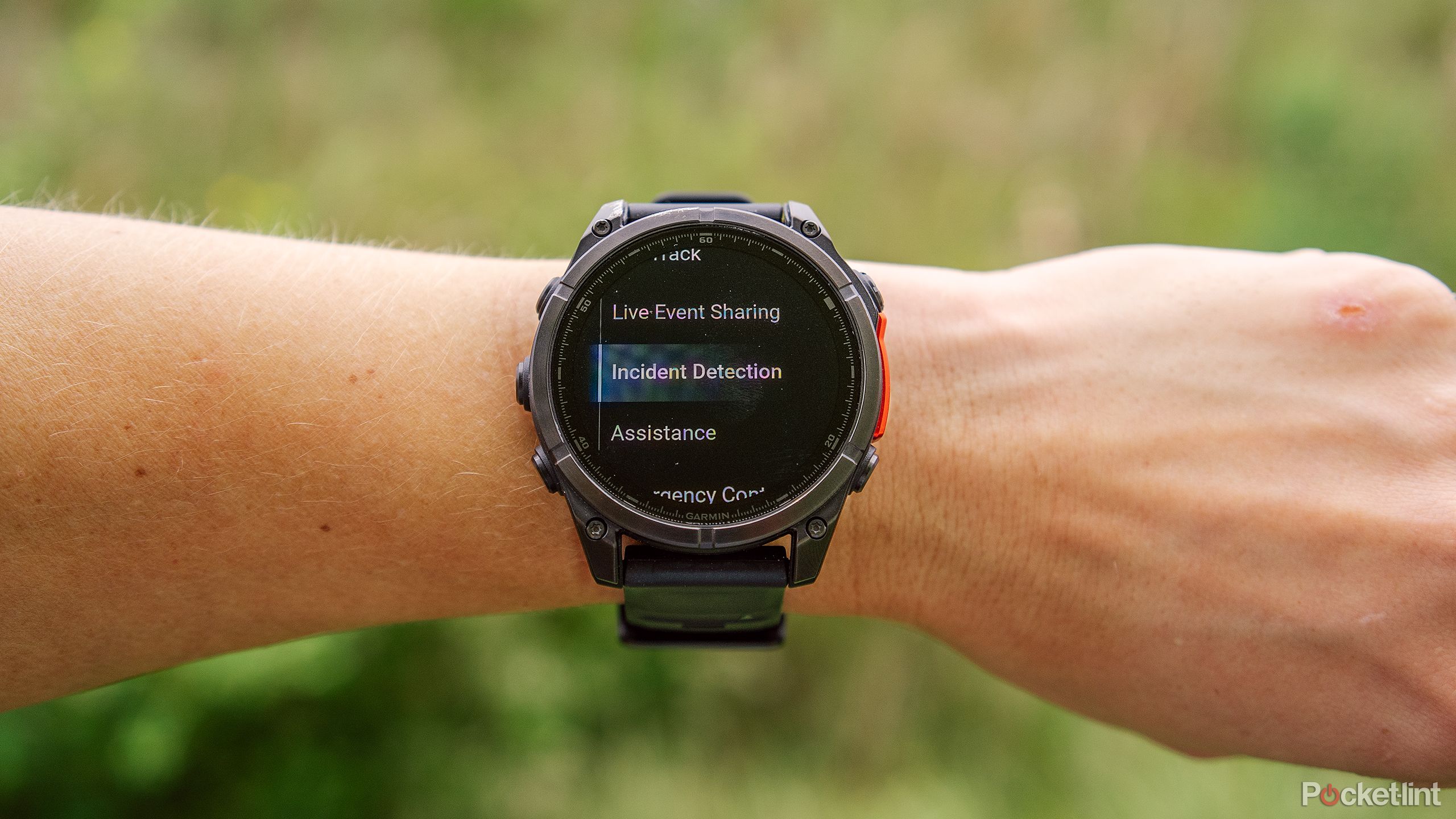 A wrist has a Garmin Fenix 8 watch on it with the Garmin Incident Detection feature on the display. 