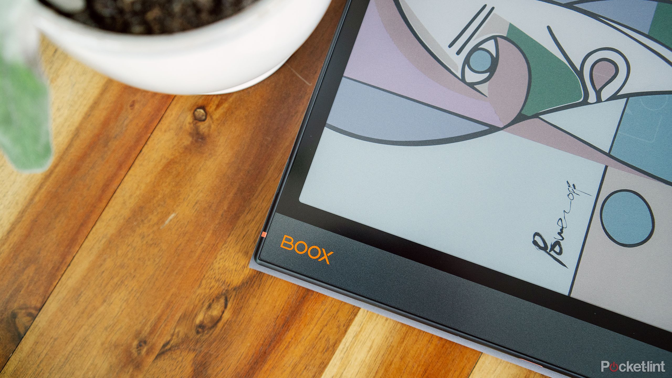 The Onyx Boox Note Air 3 C sits on a wood table. 