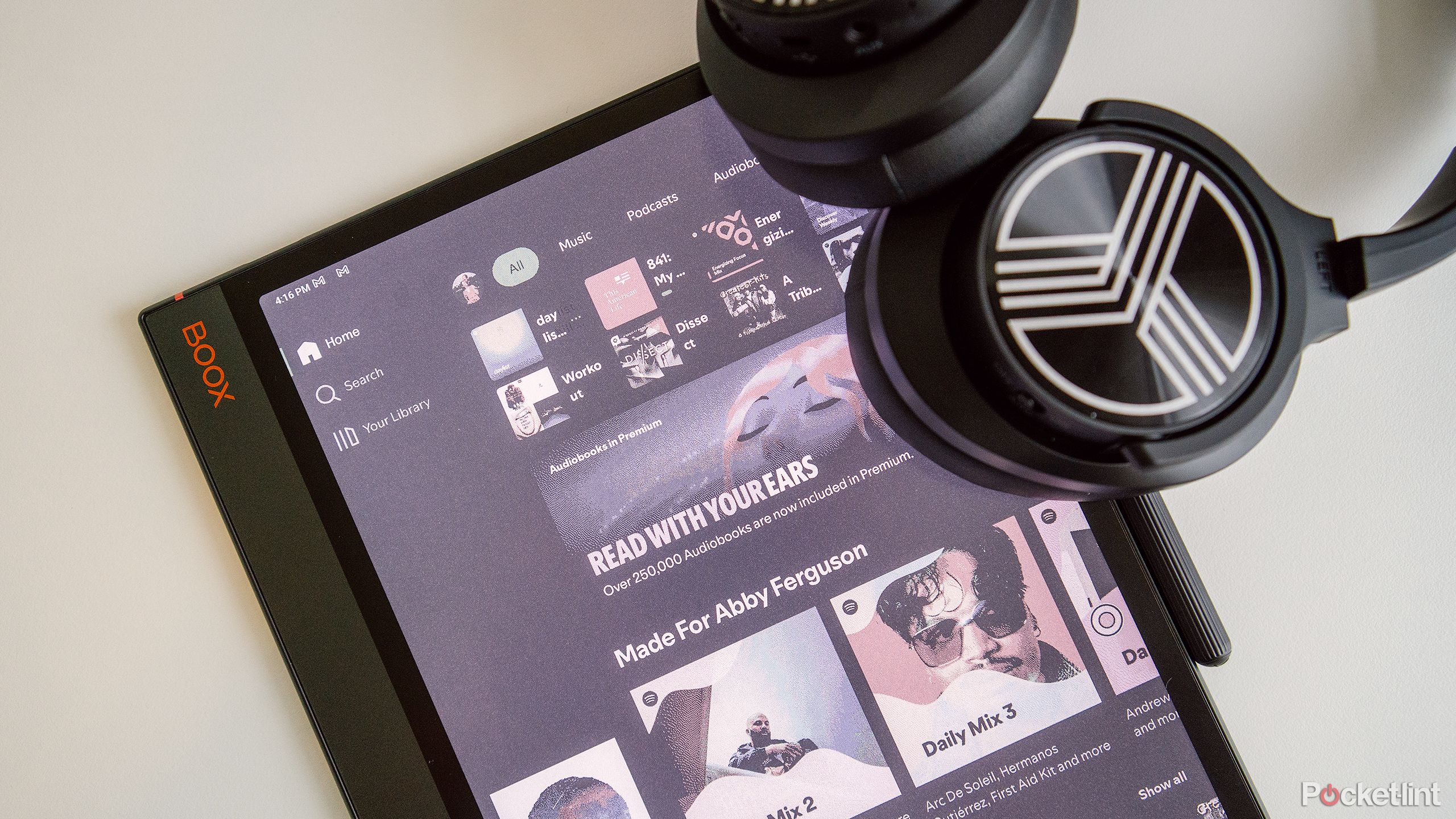 The Onyx Boox Note Air 3 C sits on a white desk with headphones. 