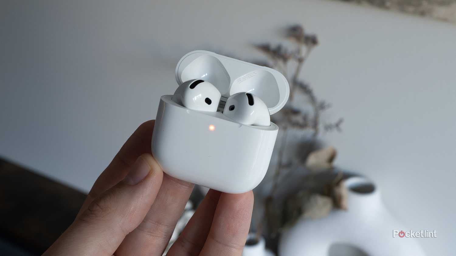 The AirPods 4 with their light on