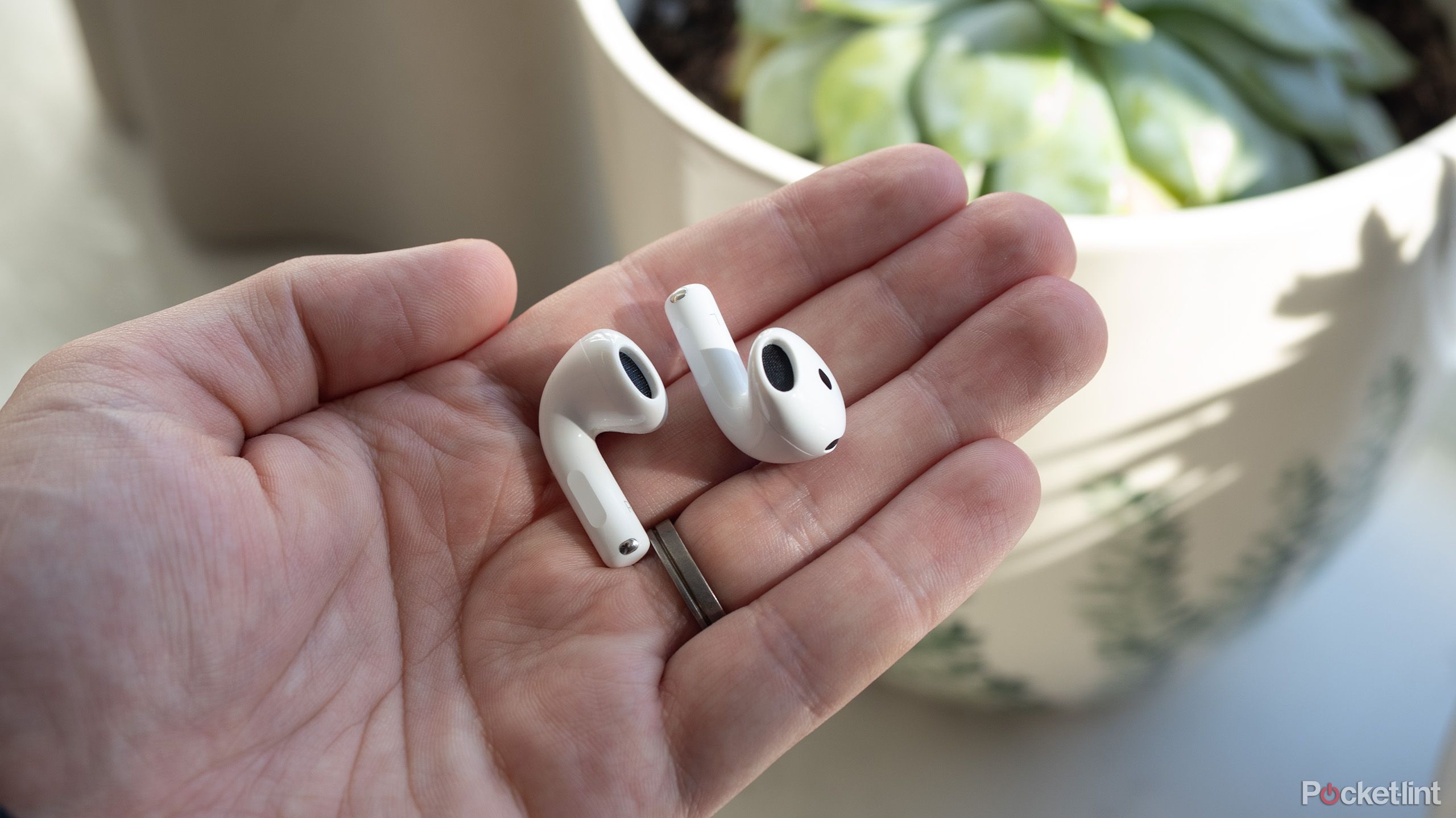 AirPods 4 earbuds in a hand