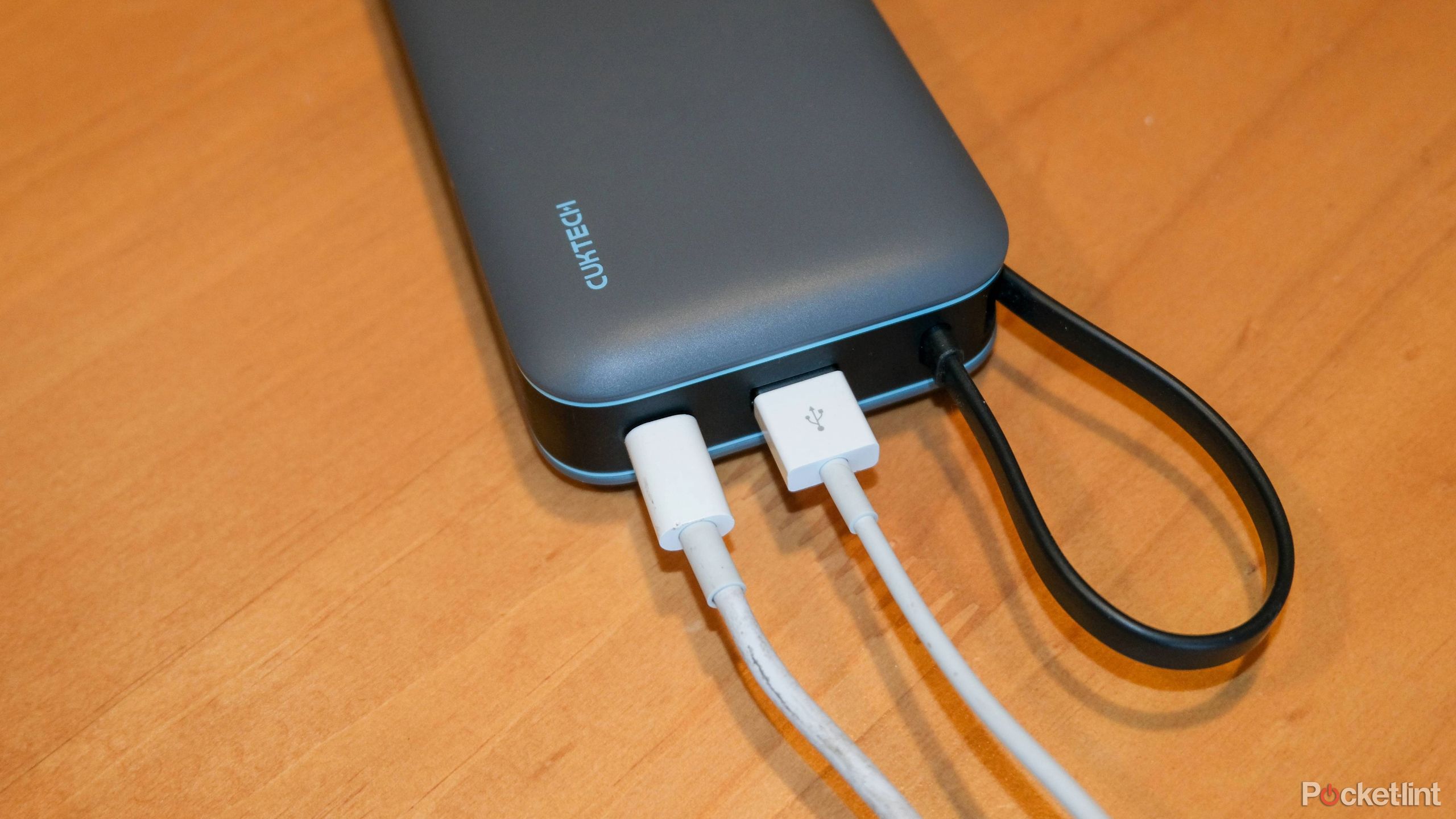 A photograph showing the Cuktech 45W 20,000 mAh power bank showing the USB-C and USB-A ports being used at the same time.