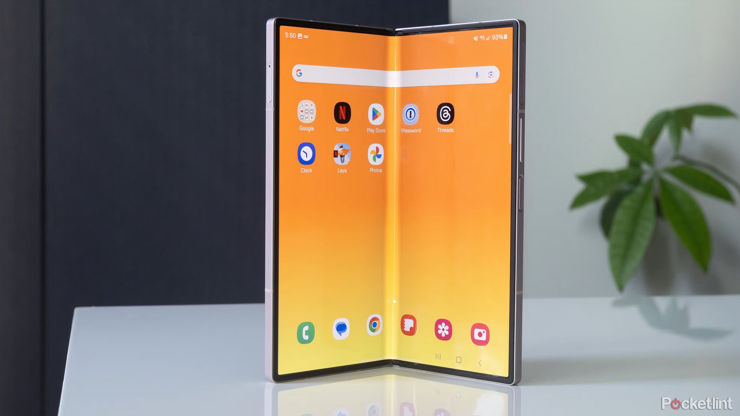 Um Samsung Galaxy Z Fold 6 prateado aberto sobre uma mesa branca.