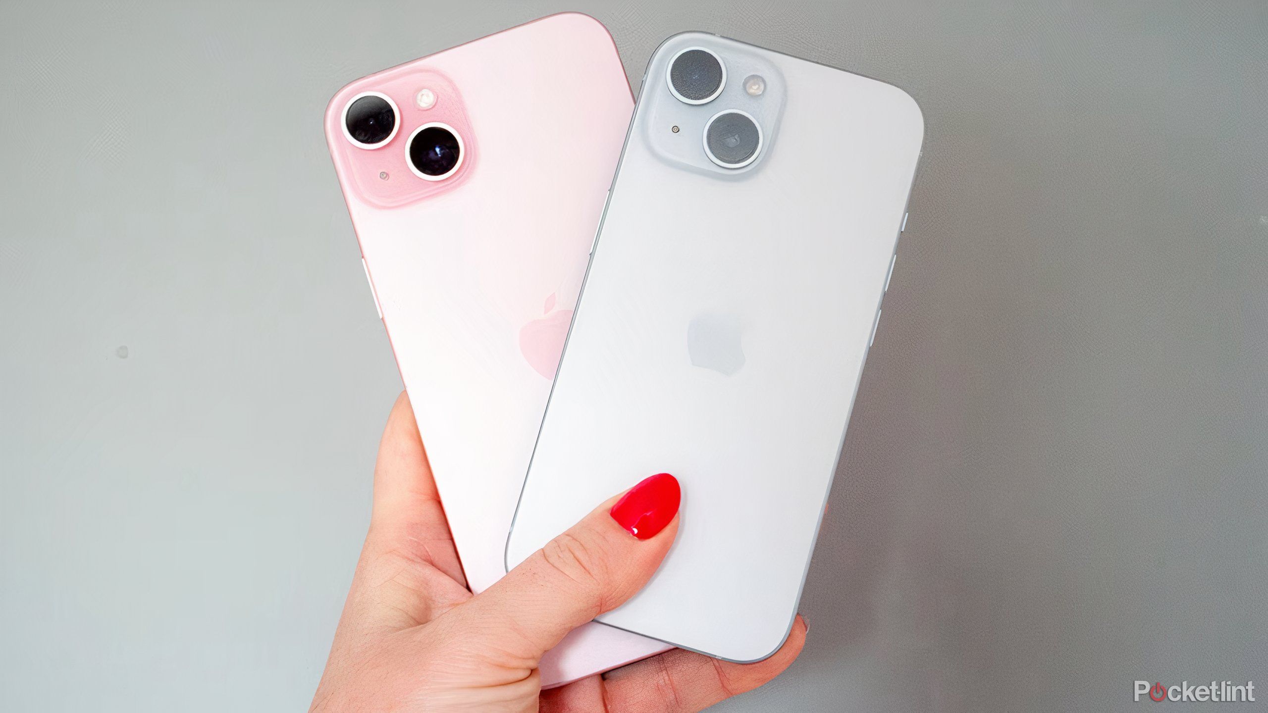 An iPhone 15 Plus and iPhone 15 being held with their backs facing forward.