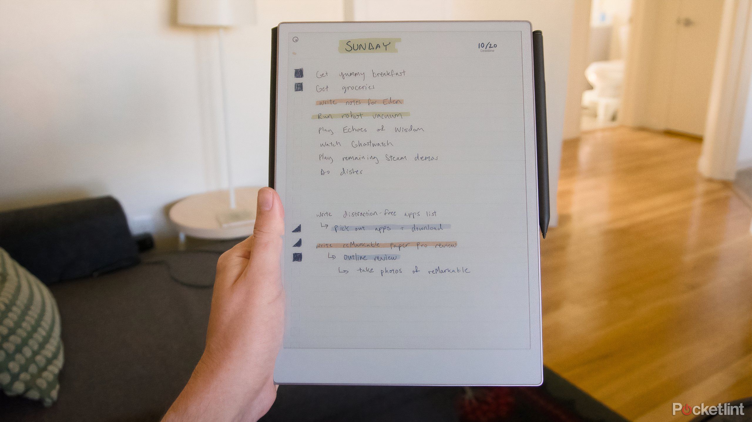 A hand holding up a to-do list on a reMarkable Paper Pro.