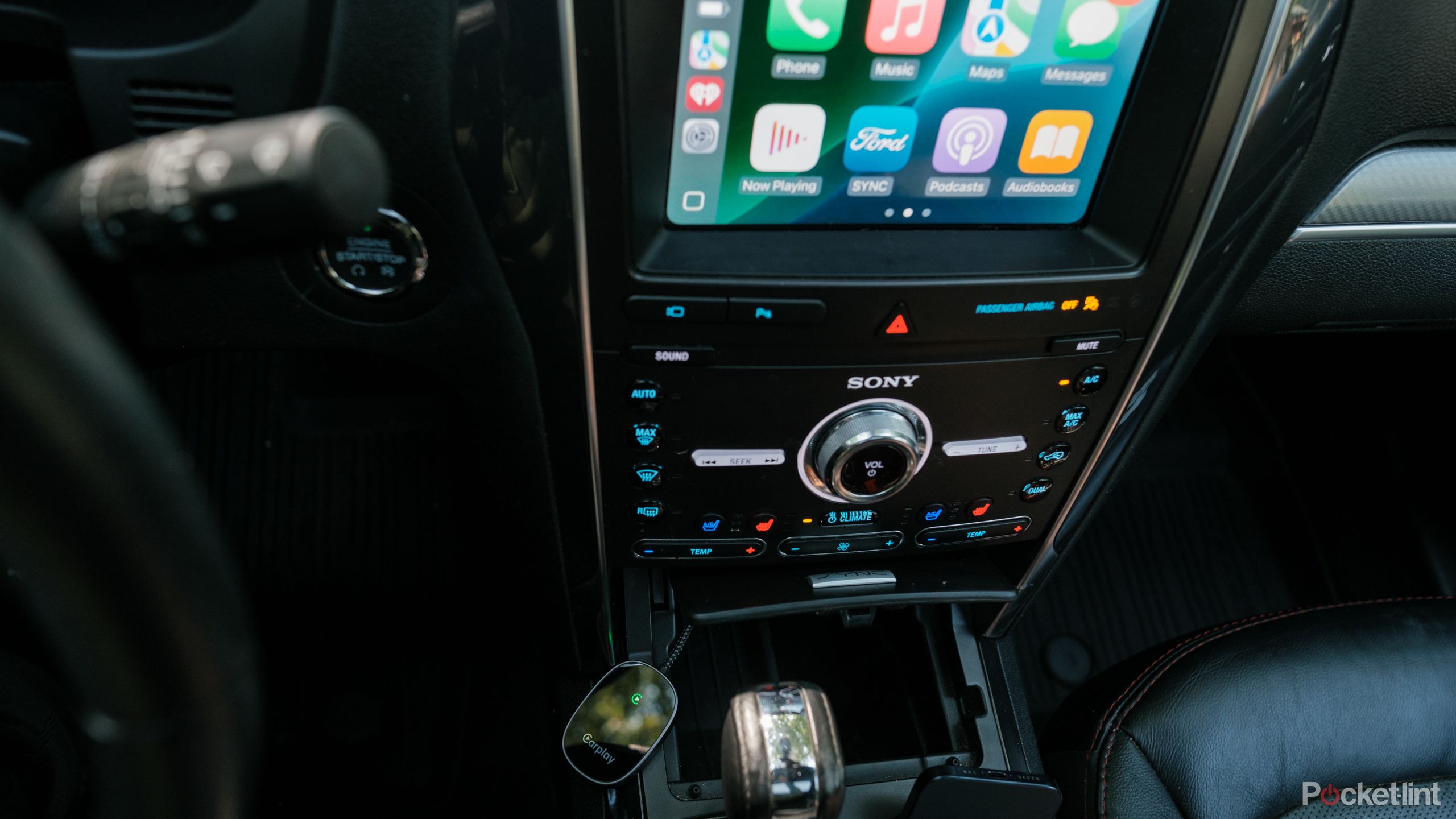 The Vevavi Wireless CarPlay adapter plugged in wide angle