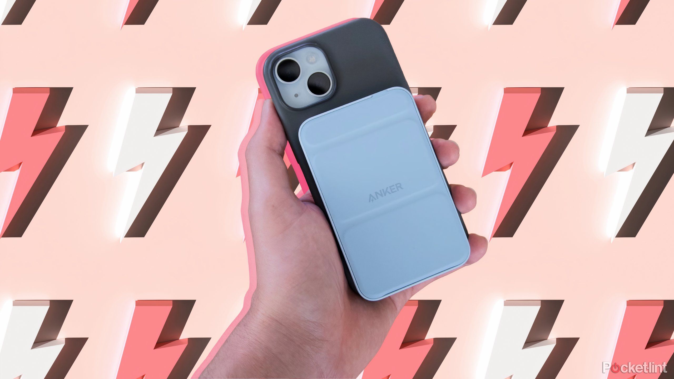 A hand holding an iPhone with an Anker Magnetic Battery Pack attached to it over a background of lightning bolts.