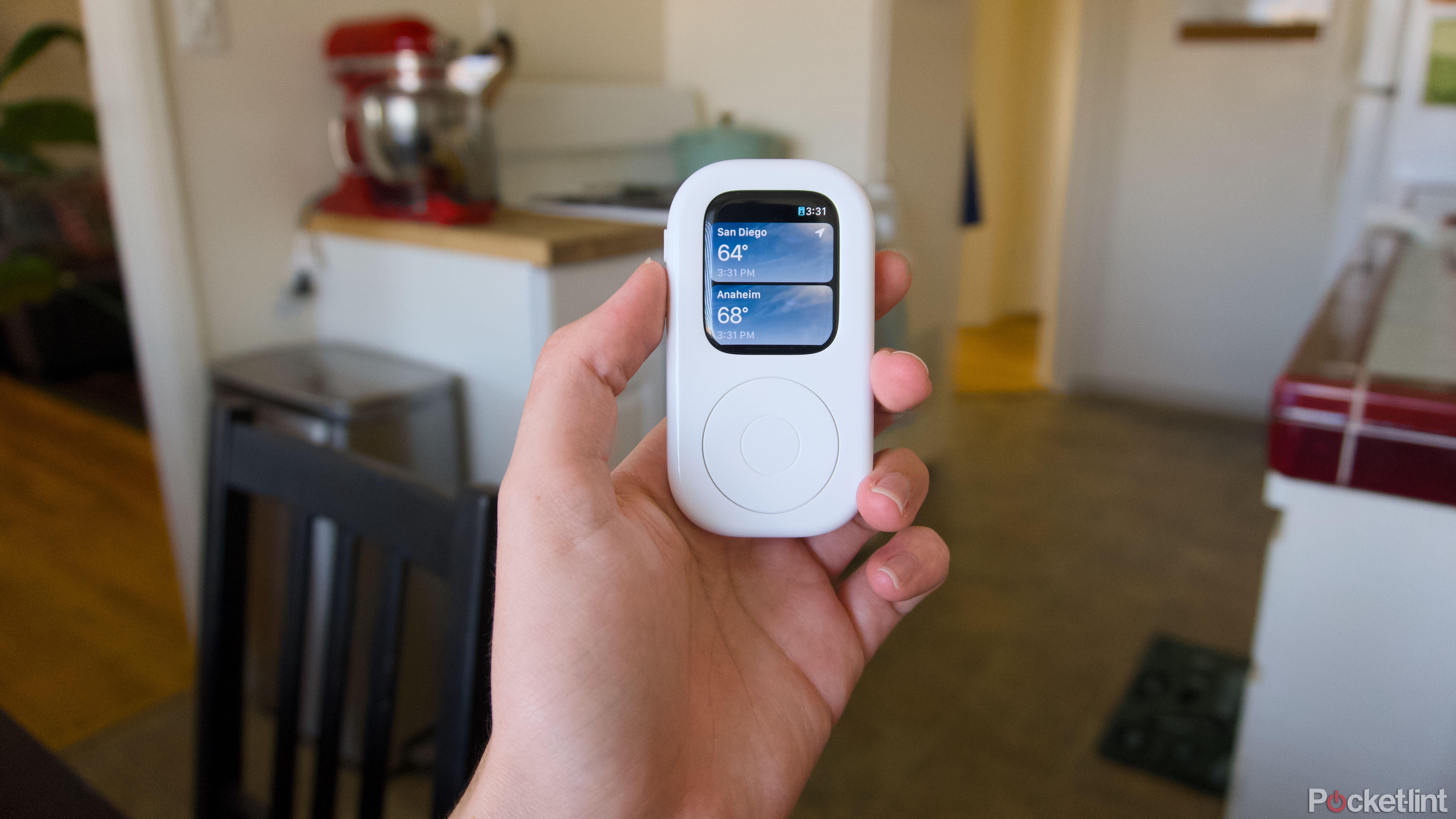 Une main tenant un tinyPod avec l’application météo Apple Watch ouverte.