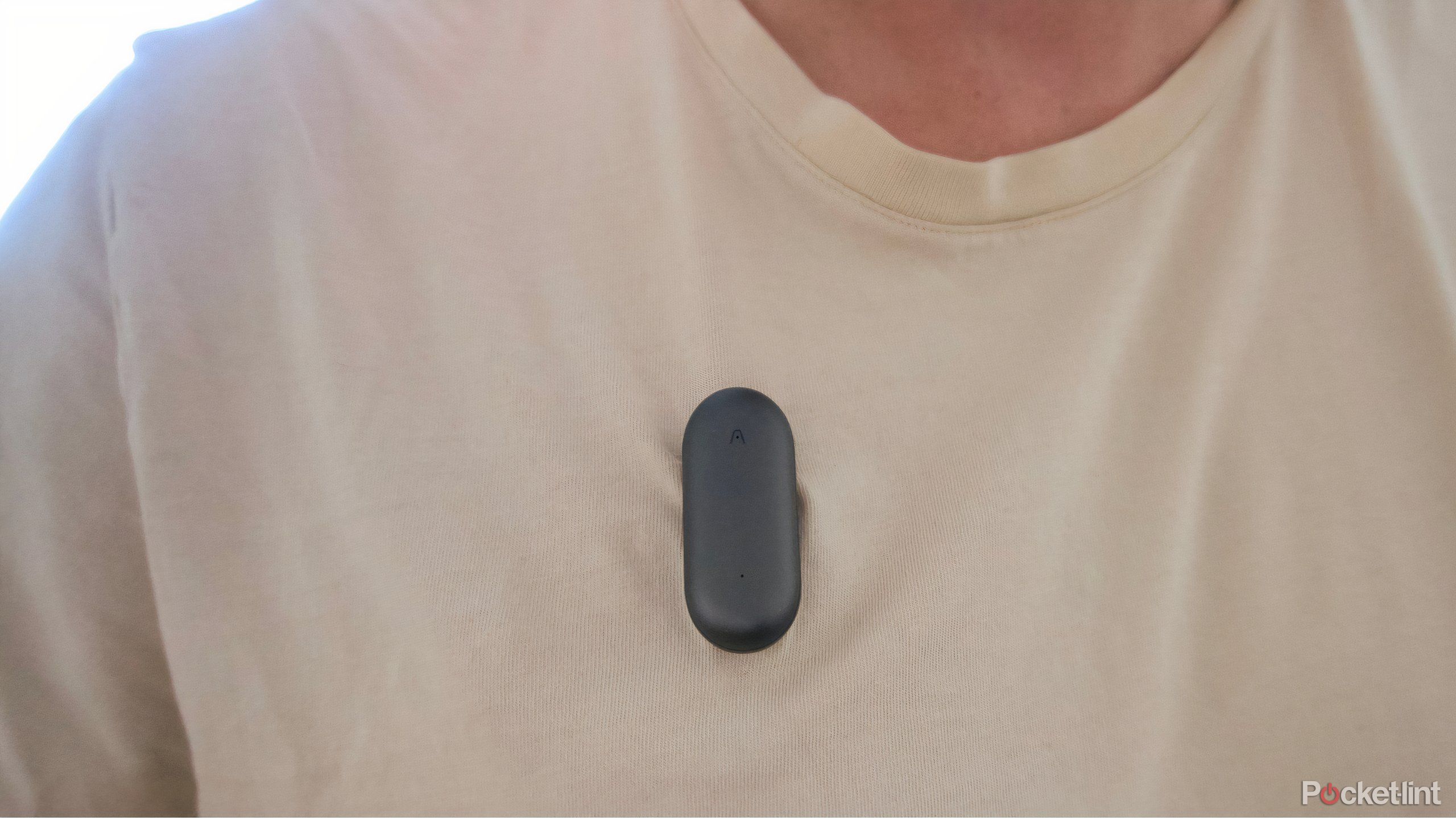 A gray Plaud NotePin pinned to a t-shirt.