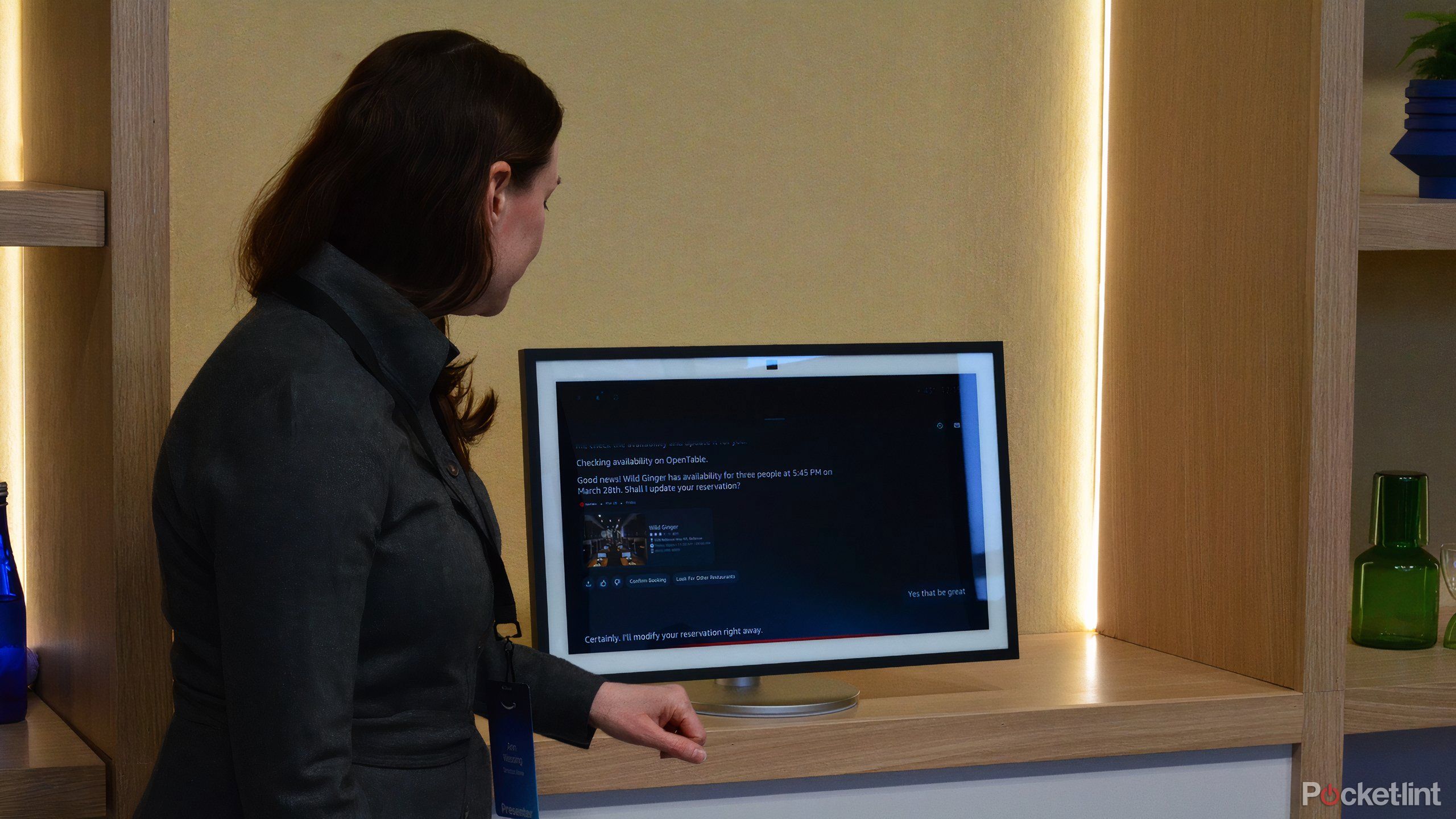 A person standing in front of a computer monitor. 