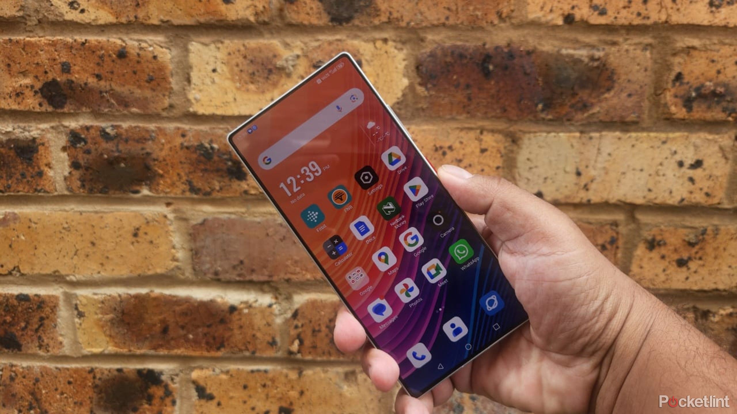 Nubia Z70 Ultra in hand against a brick wall. 