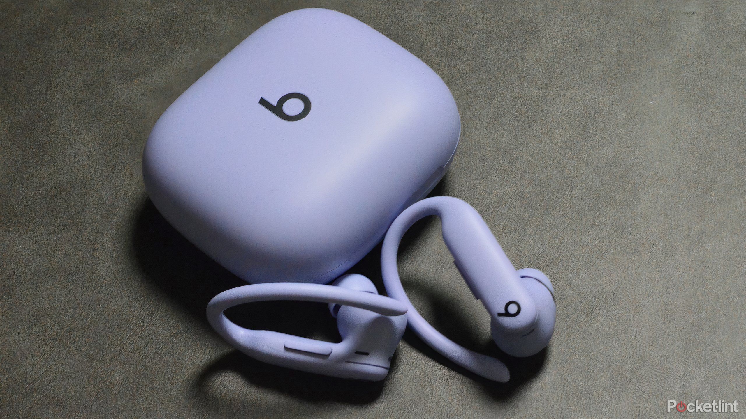 Powerbeats Pro 2 in purple beside their case. 