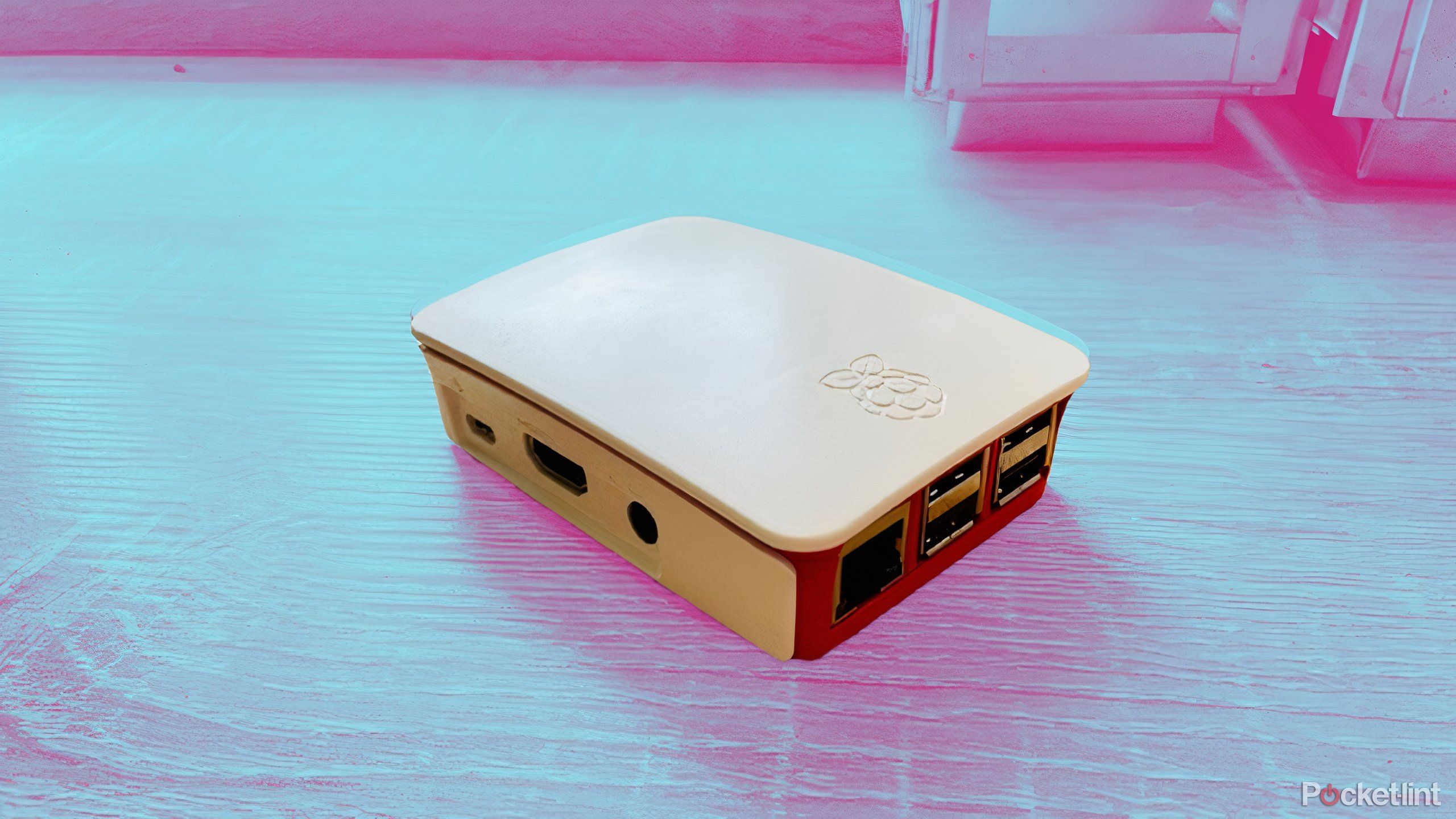 A Raspberry Pi 3B in the official case on a colored background.