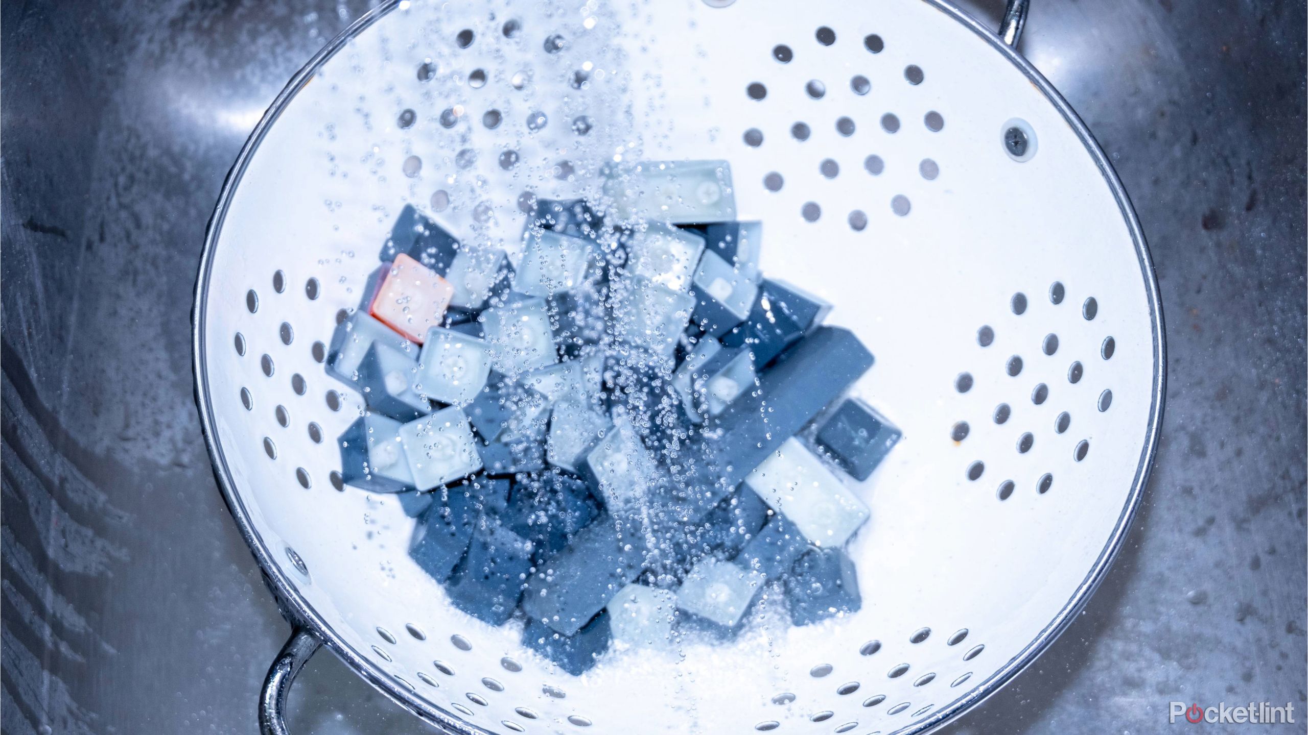 A photograph of keys being rinsed in a strainer. 