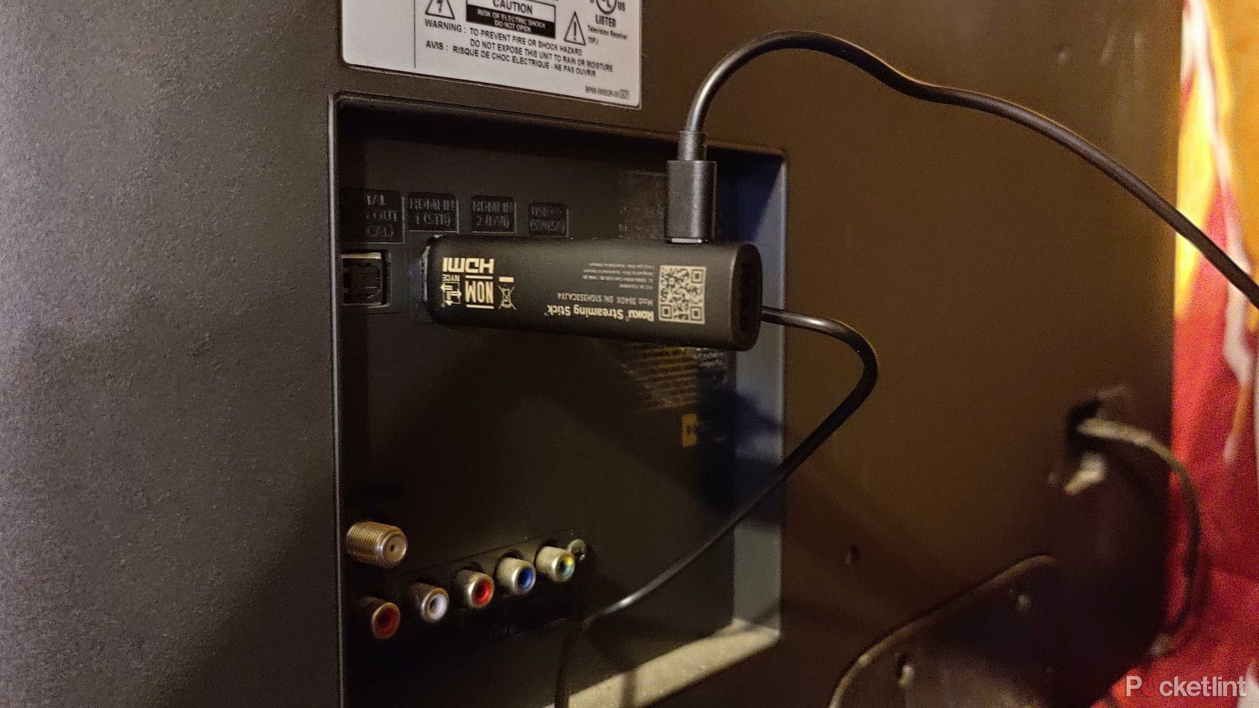 Roku USB TV stick plugged into a TV. 