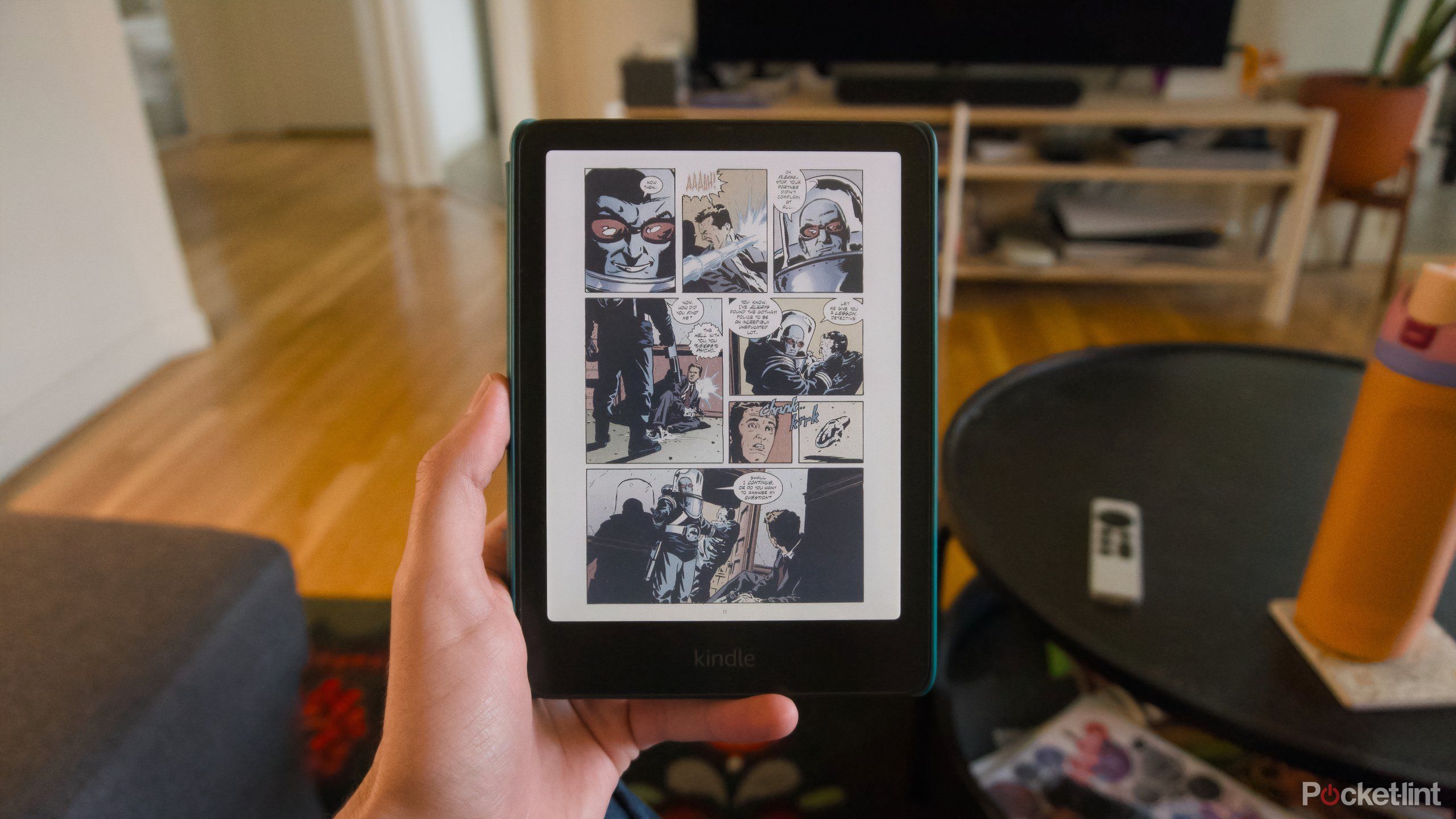 A hand holding a Kindle Colorsoft displaying a Batman comic.