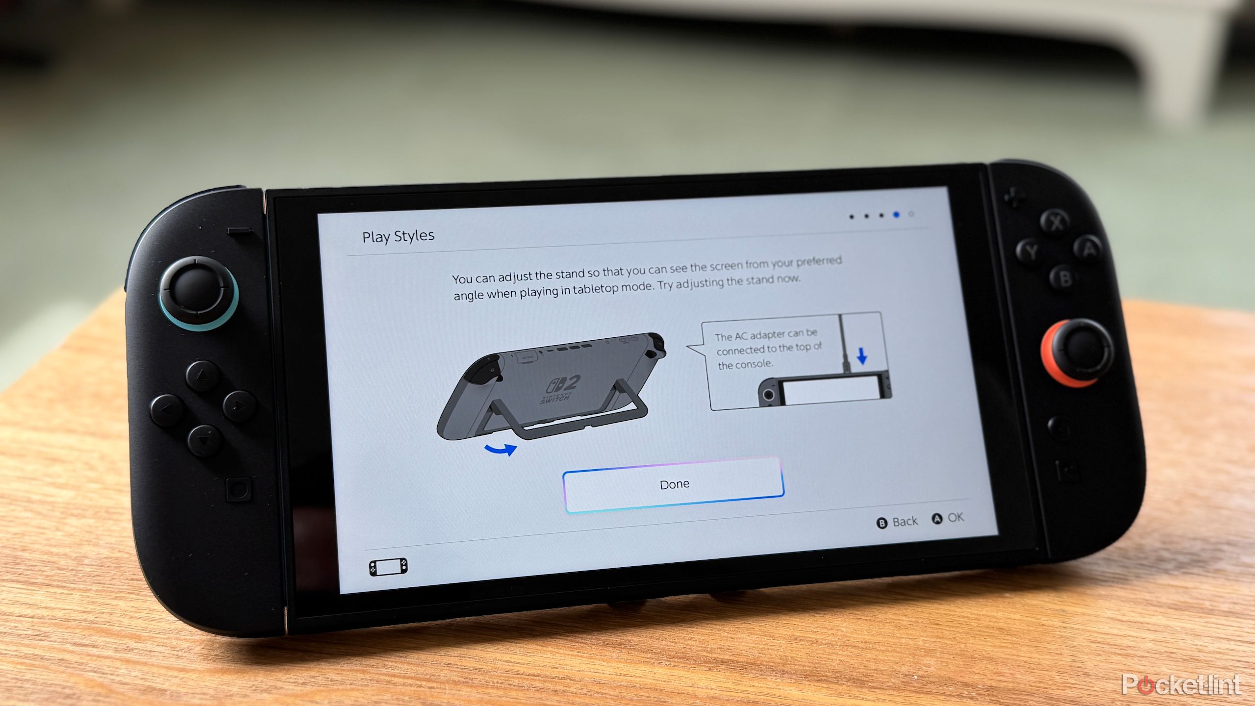 A Nintendo Switch 2 standing upright on its kickstand displaying information about how to use the kickstand.