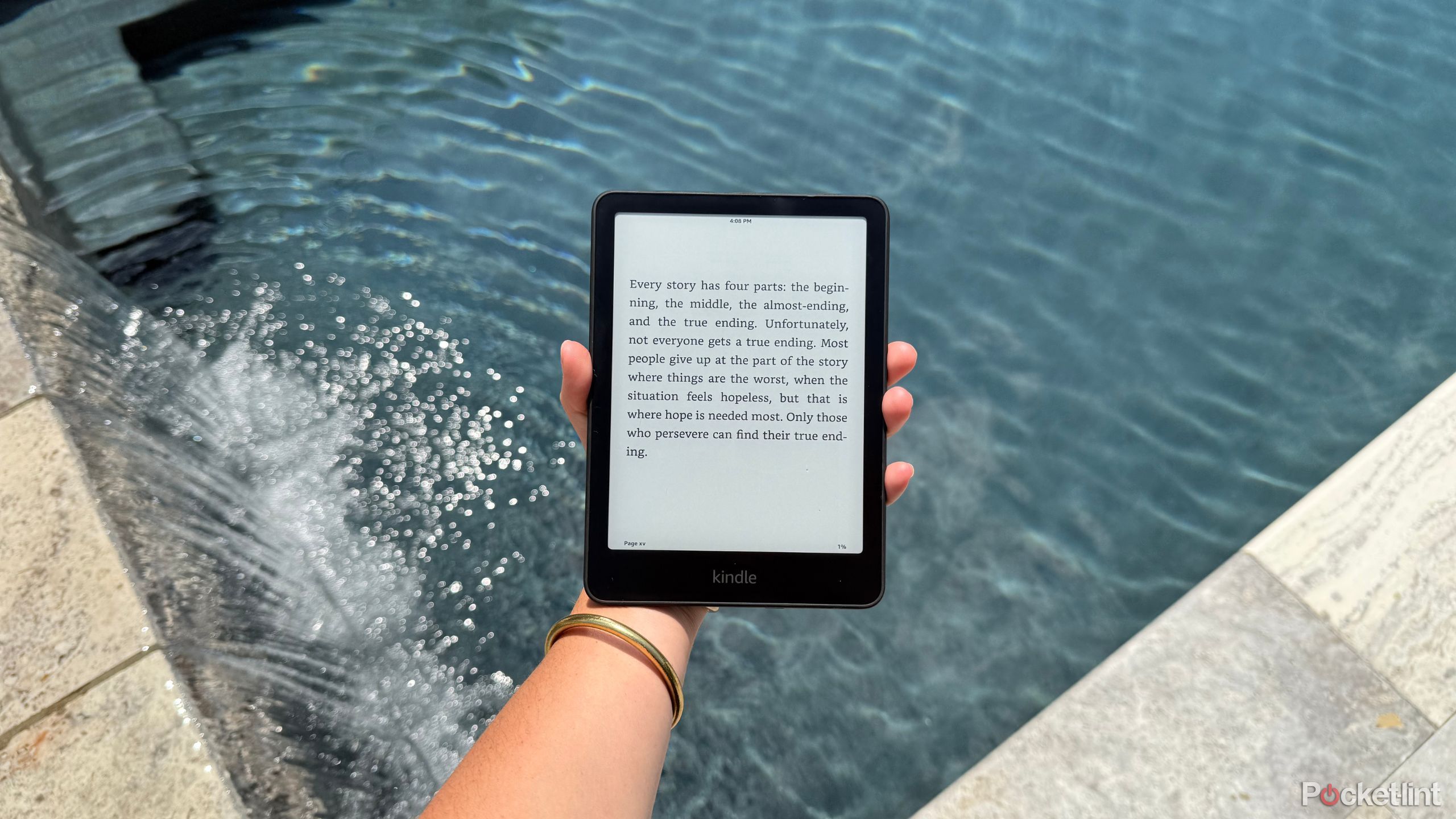 Holding a Kindle Paperwhite over a pool.