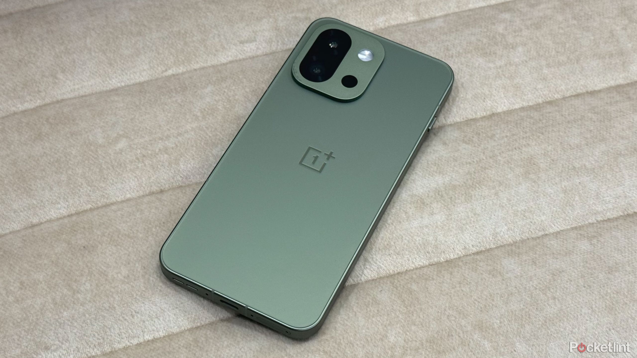 OnePlus 13s on an off white sofa